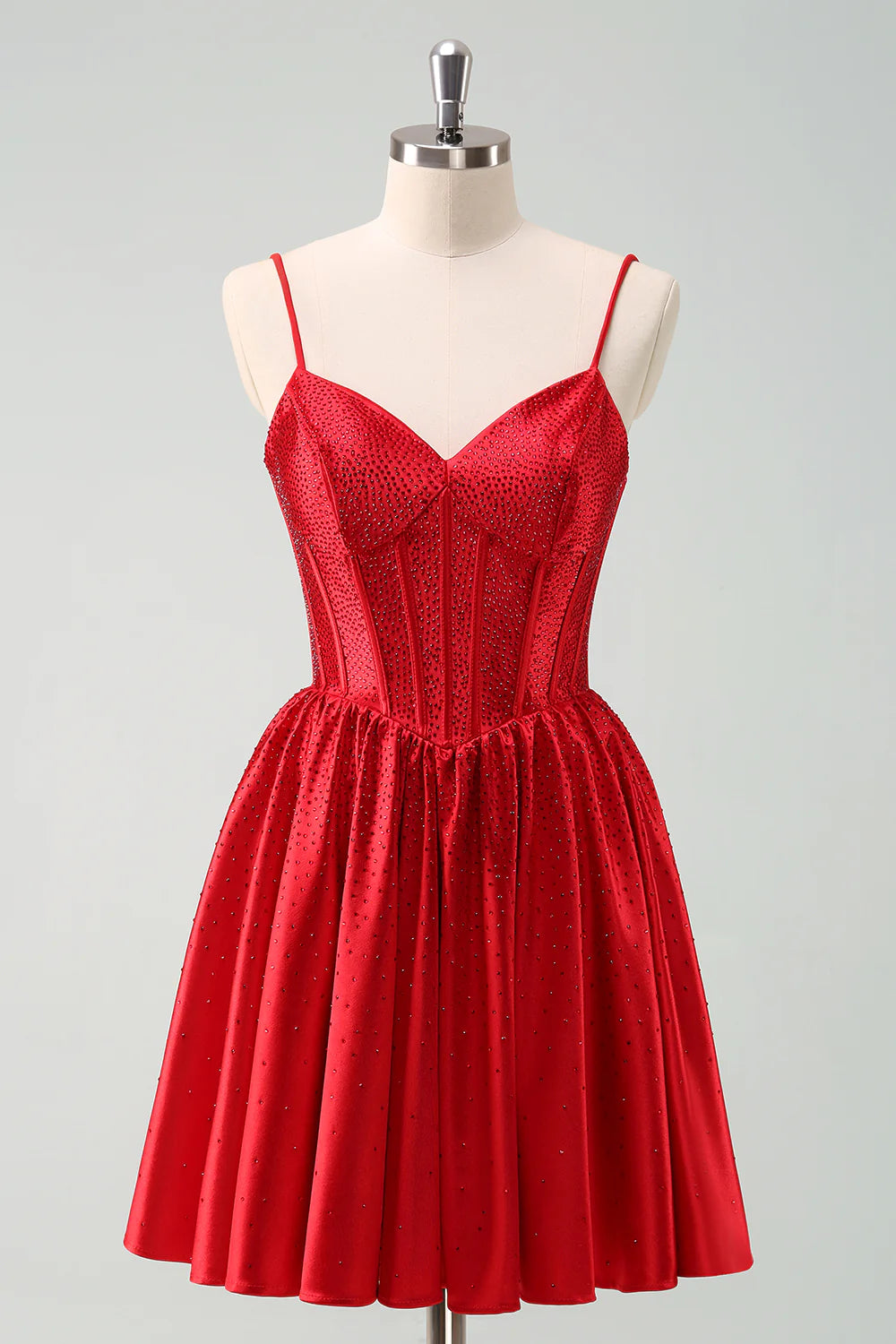 Front view of a charming red A-line short homecoming dress with spaghetti straps, ruffle, corset, and beading.
