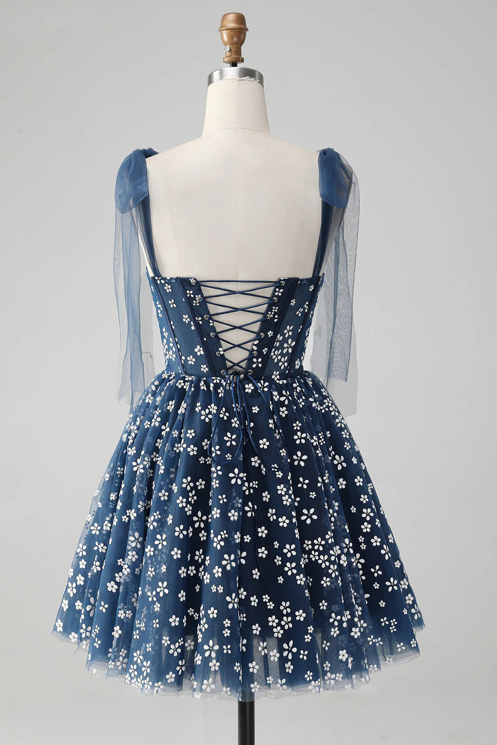 Side view of the navy A-line short homecoming dress with printed corset detail.