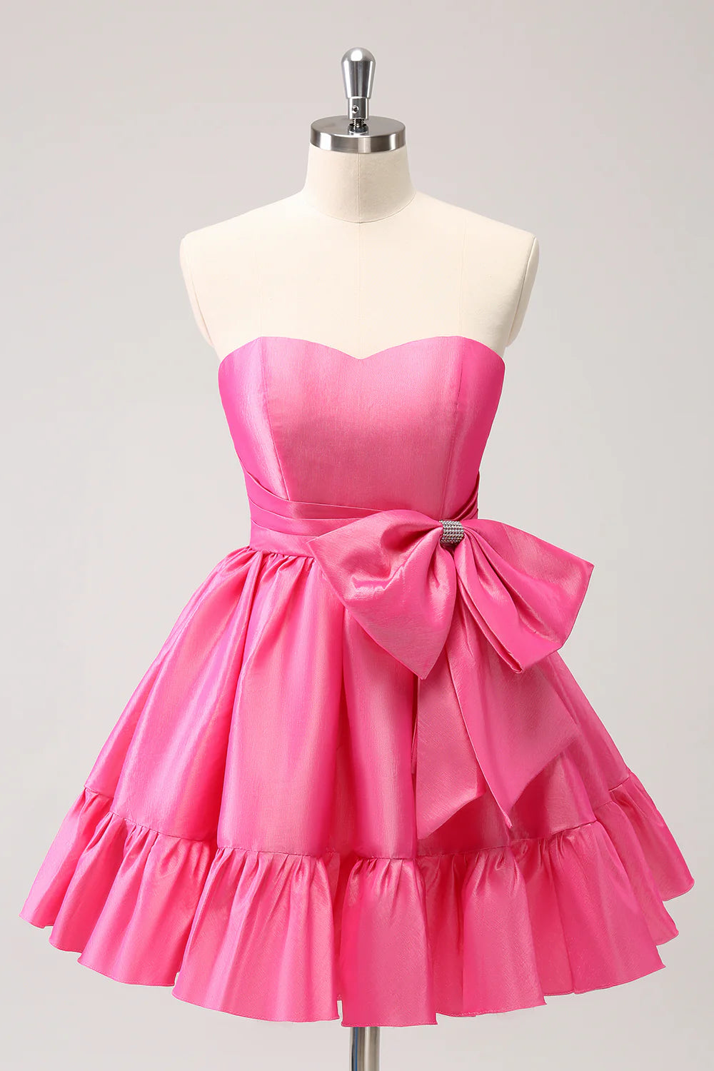 Model wearing a hot pink A-line strapless short homecoming dress with a bow detail, front view.