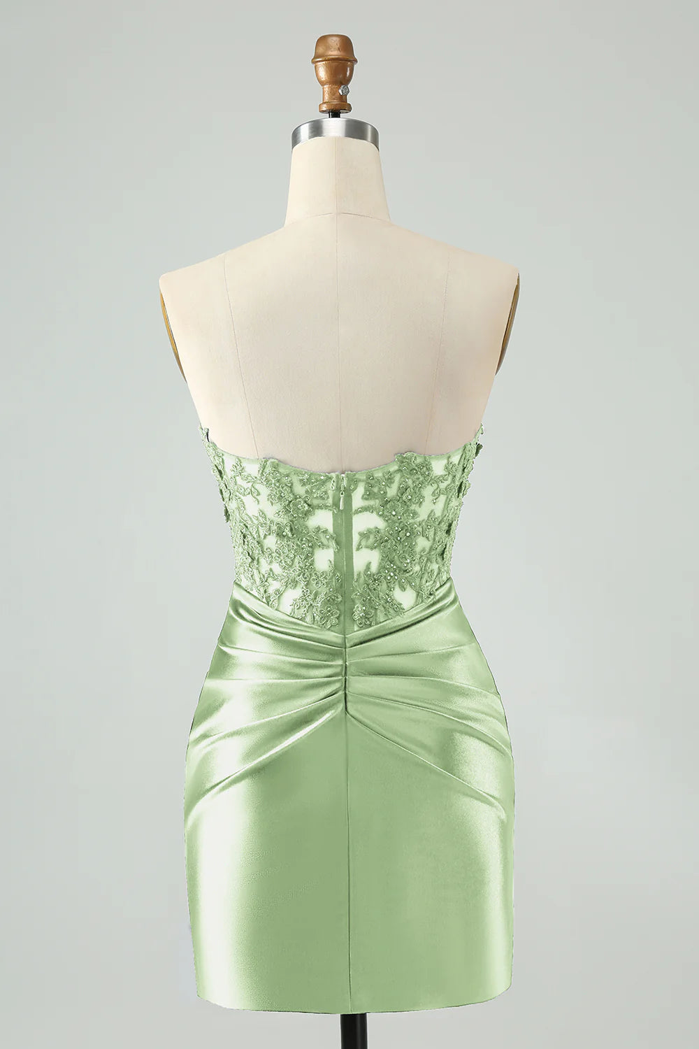 Model posing in a green short bodycon dress with hollow-out and beading.