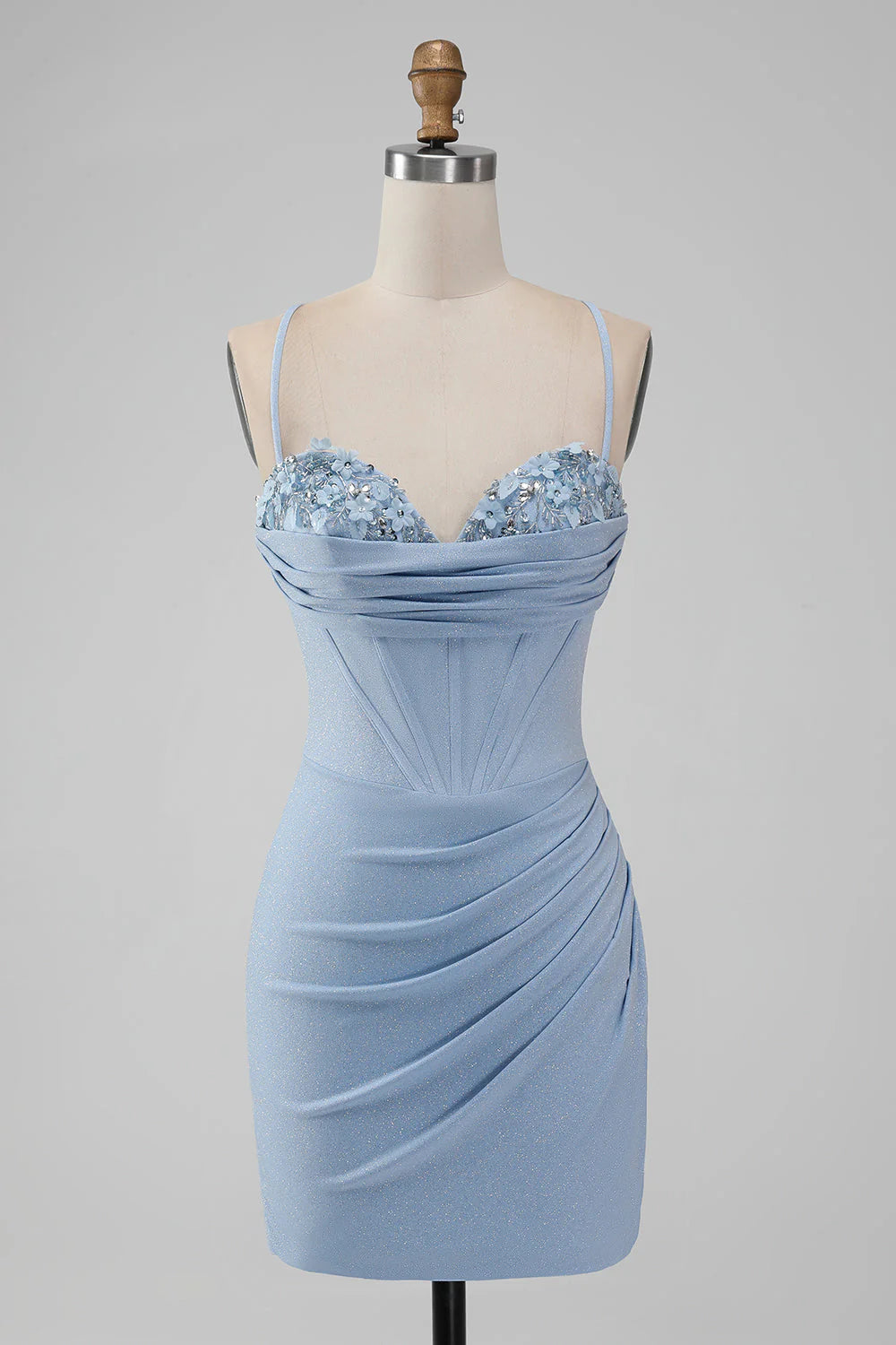 Model wearing a light blue bodycon short homecoming dress with spaghetti straps and corset bodice, front view.
