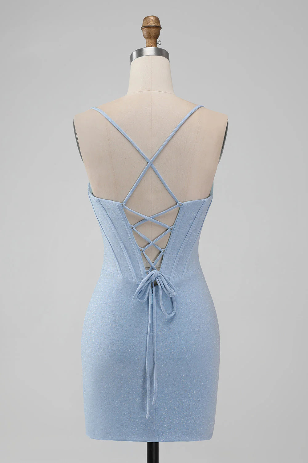 Model wearing a light blue bodycon short homecoming dress with spaghetti straps and corset bodice, side view.