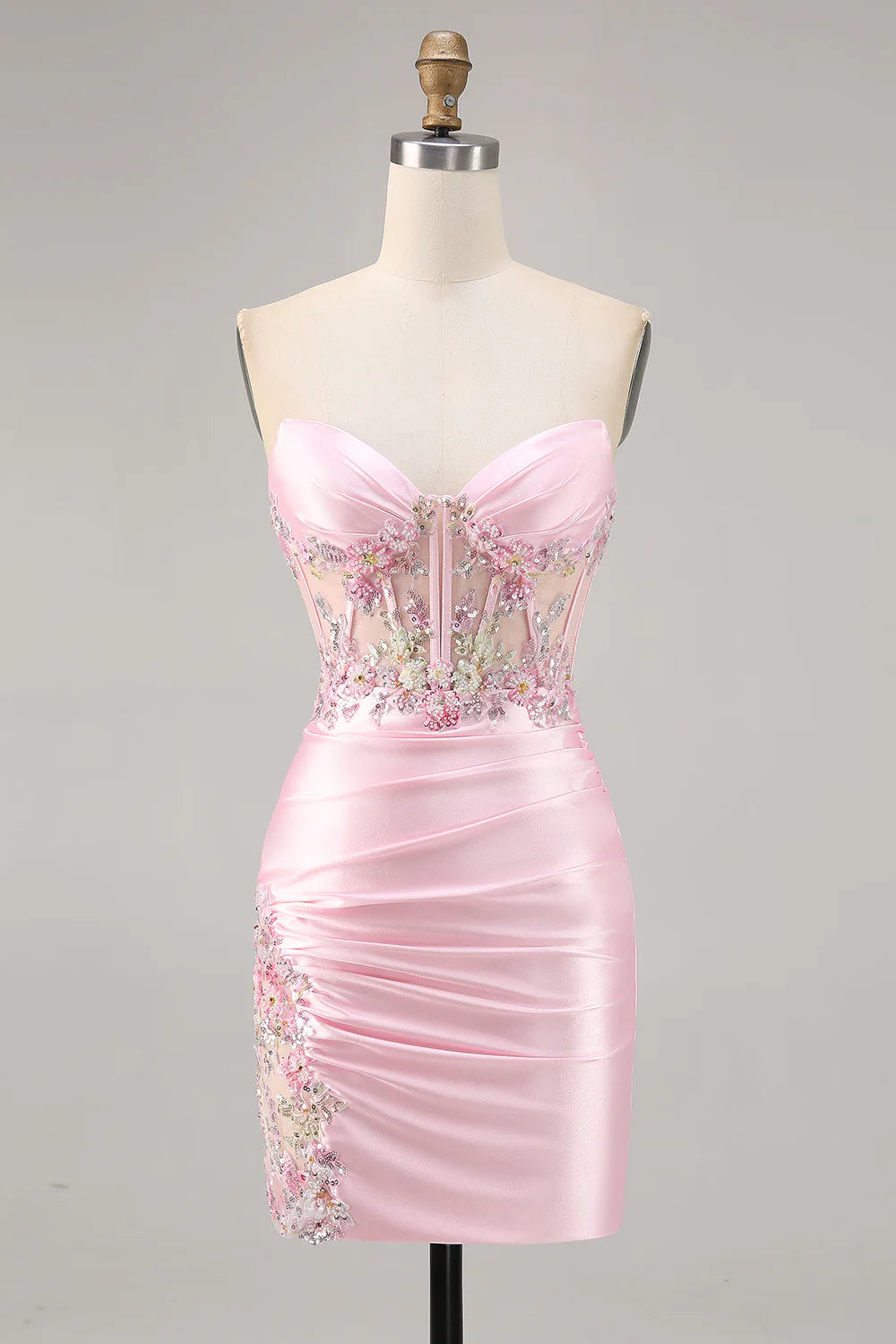 Model wearing a Candy Pink strapless ruched short homecoming dress with appliques.