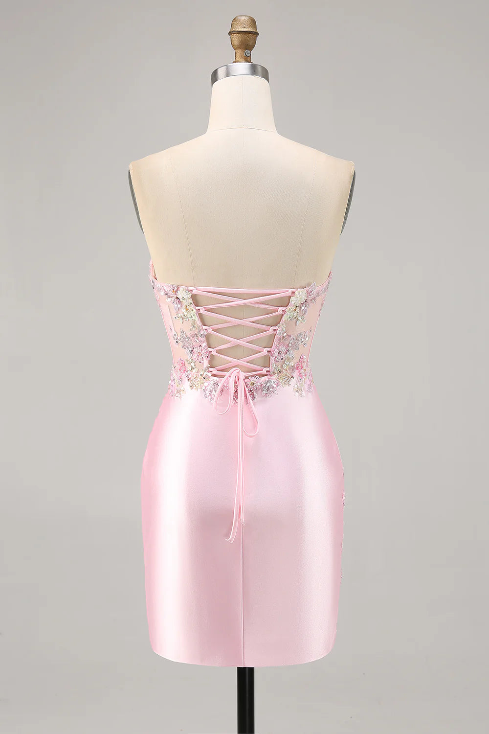 Back view of a Candy Pink strapless ruched short homecoming dress with appliques.