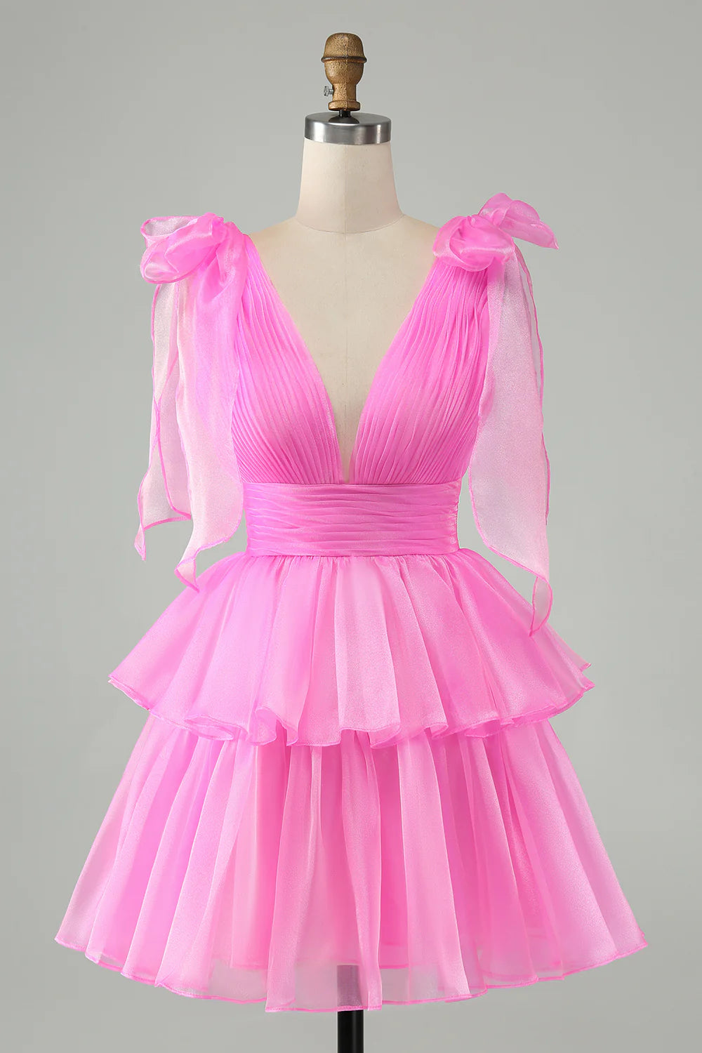 Model wearing a hot pink A-line V-neck backless pleated tiered short homecoming dress.