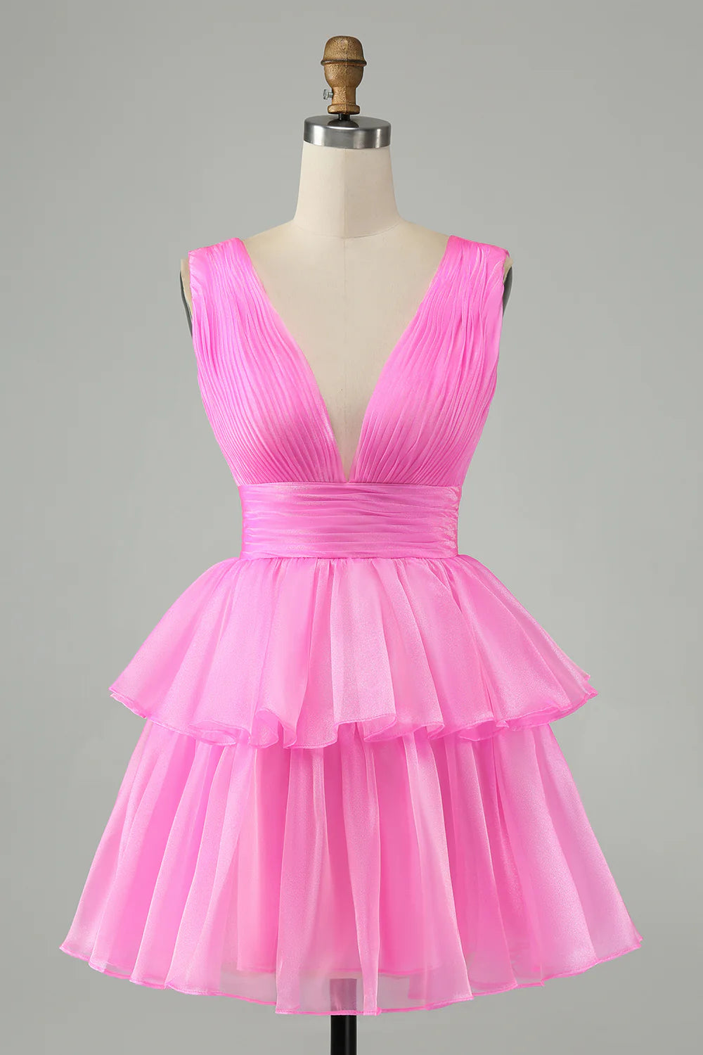 Close-up of the pleated tiered skirt of a hot pink homecoming dress.