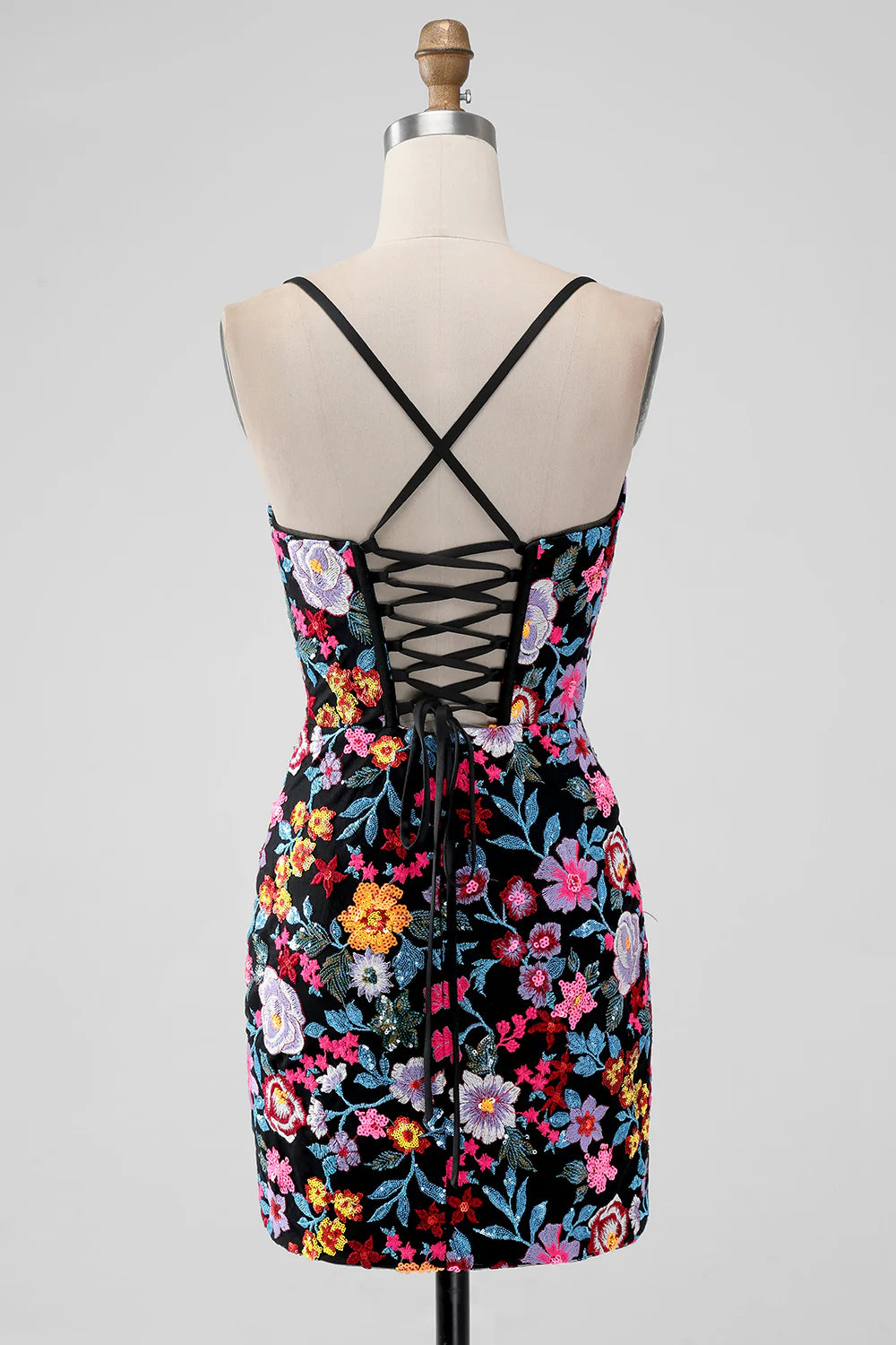 Close-up of the floral embroidery on a black spaghetti strap homecoming dress.