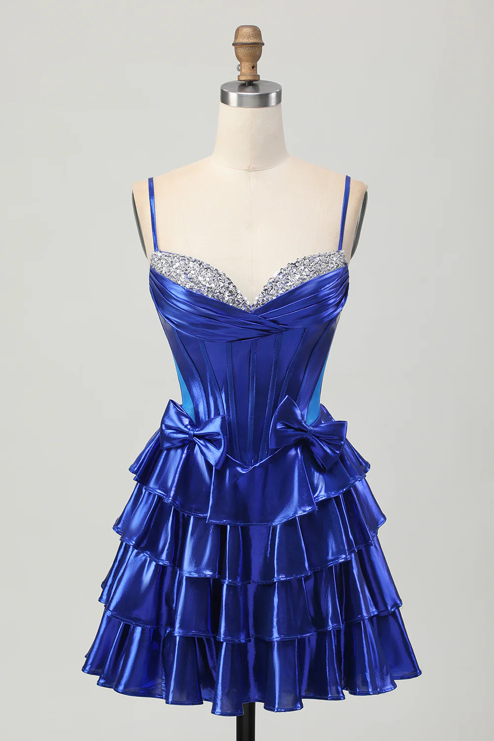 Royal blue A-line homecoming dress with spaghetti straps, corset bodice, tiered skirt, and beaded details.
