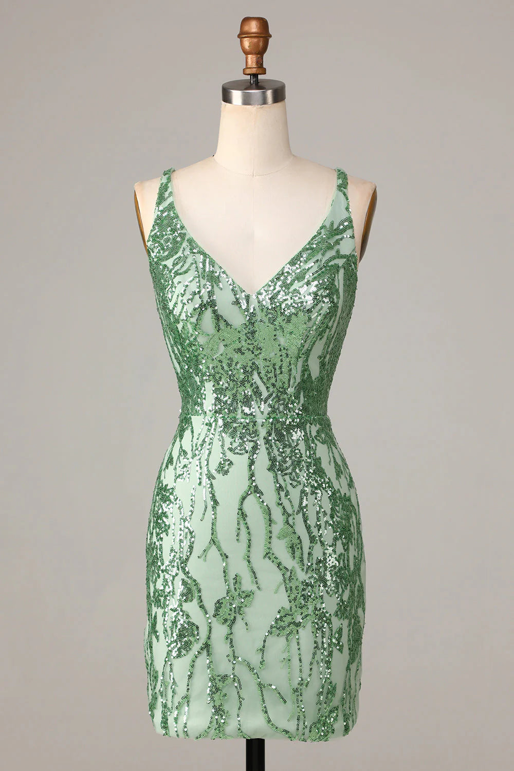 Model wearing a sparkly green sequin sheath V-neck short homecoming dress with a backless design.