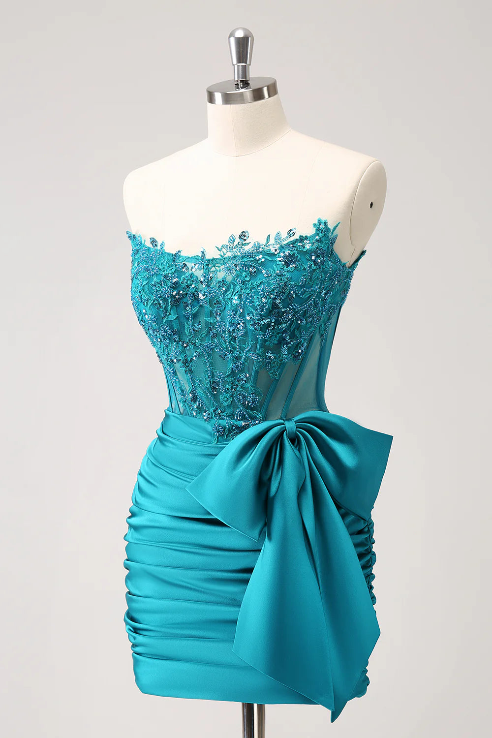Side view of a peacock strapless homecoming dress, highlighting the beaded corset and flowing short skirt.