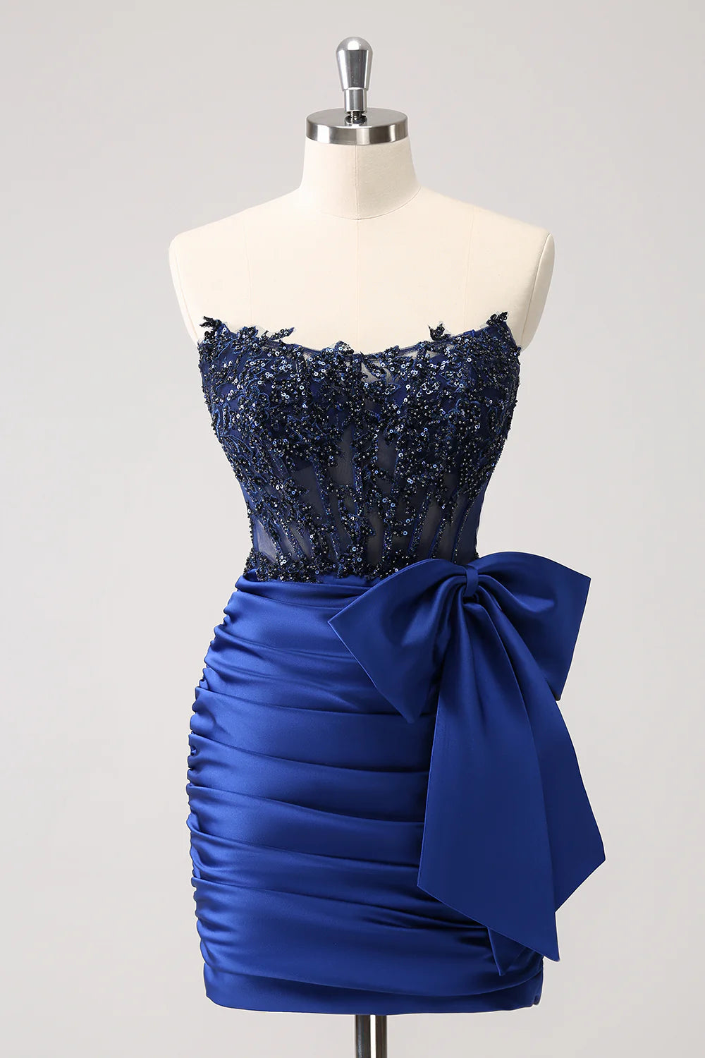 Elegant navy blue strapless corset homecoming dress with beaded details and a short pleated skirt.