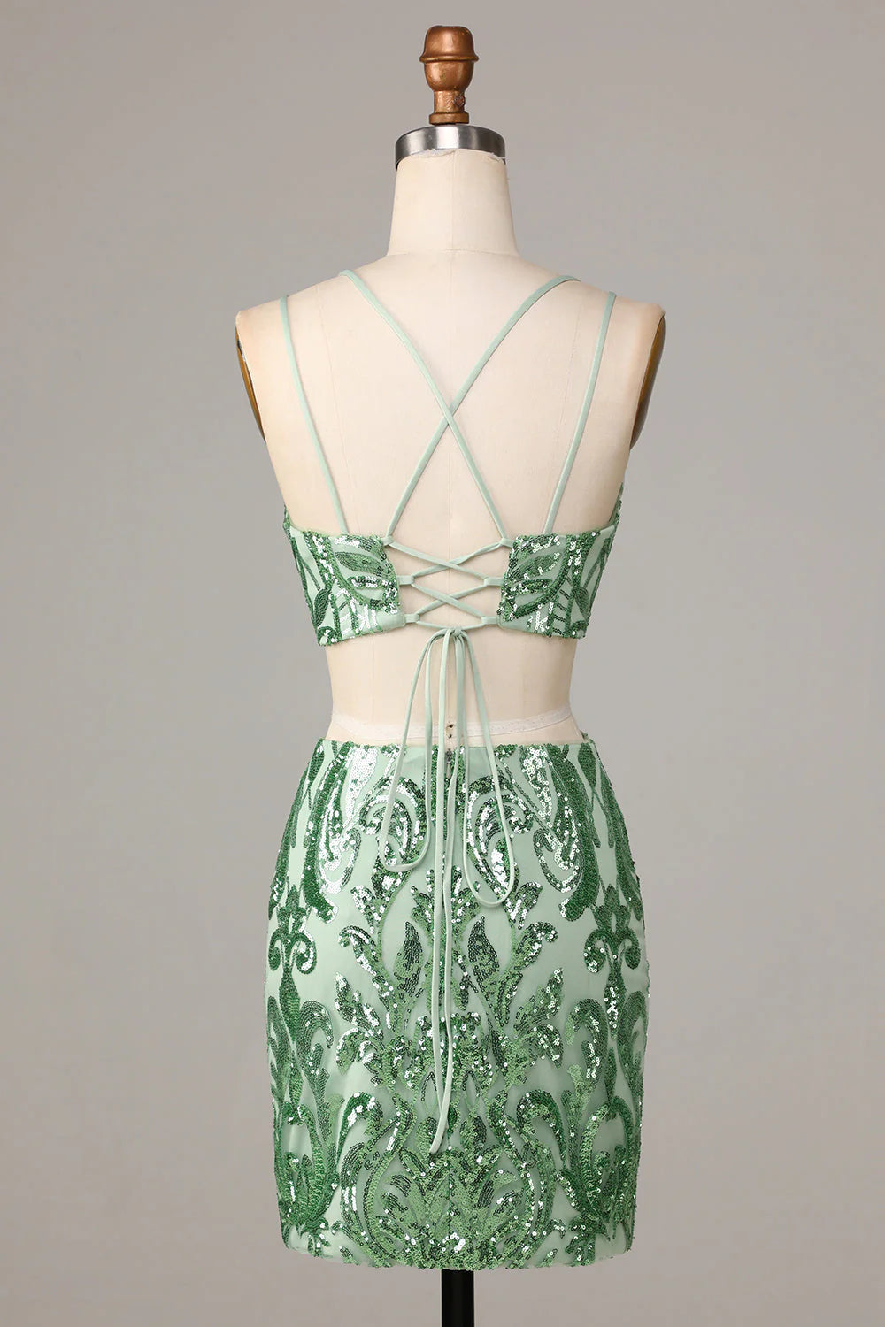 Side view of a model showcasing the shimmering green sequin two-piece homecoming dress.