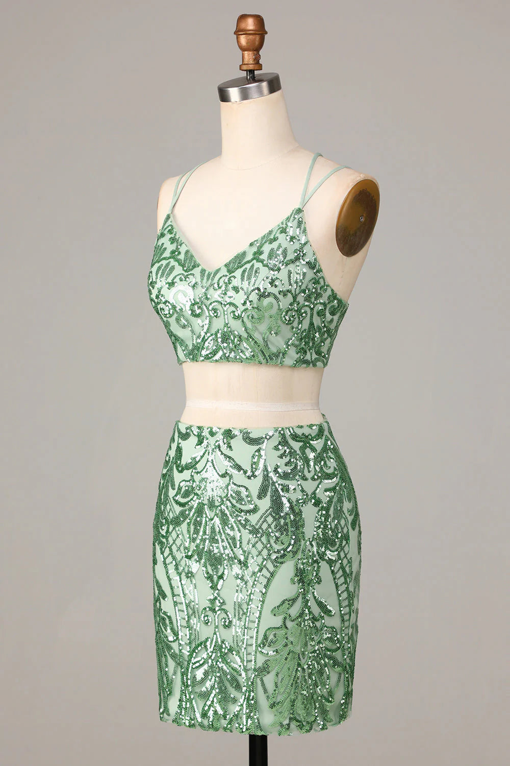 Back view of a model in the sparkling green two-piece spaghetti strap short dress.
