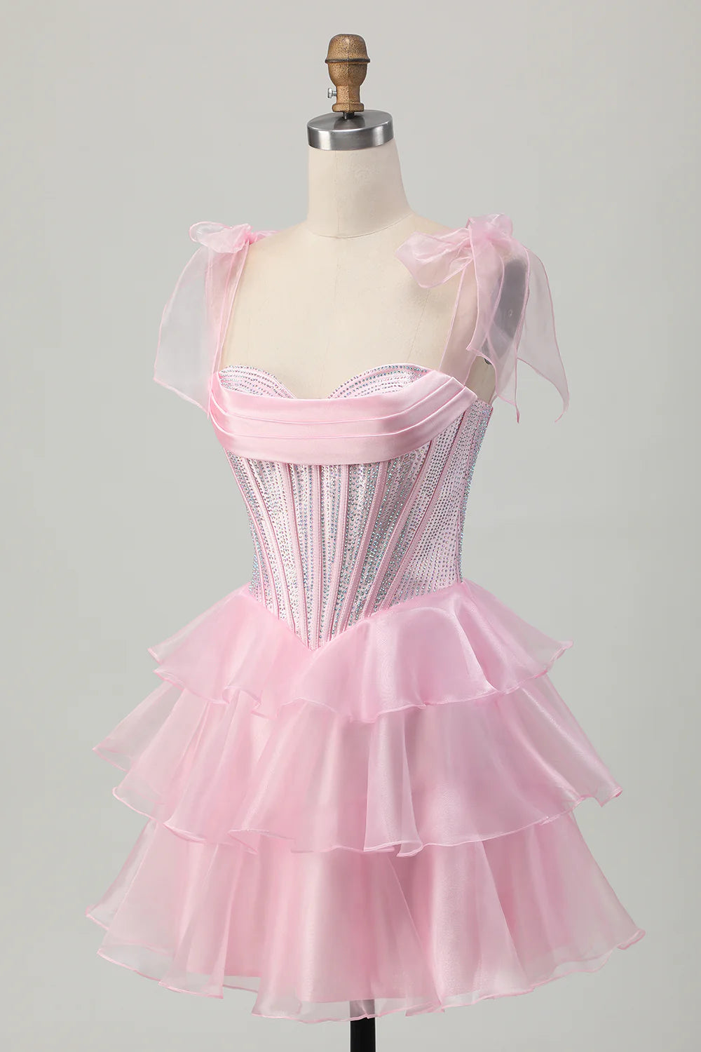 Back view of the pink corset homecoming dress, featuring delicate beading and a charming bow.