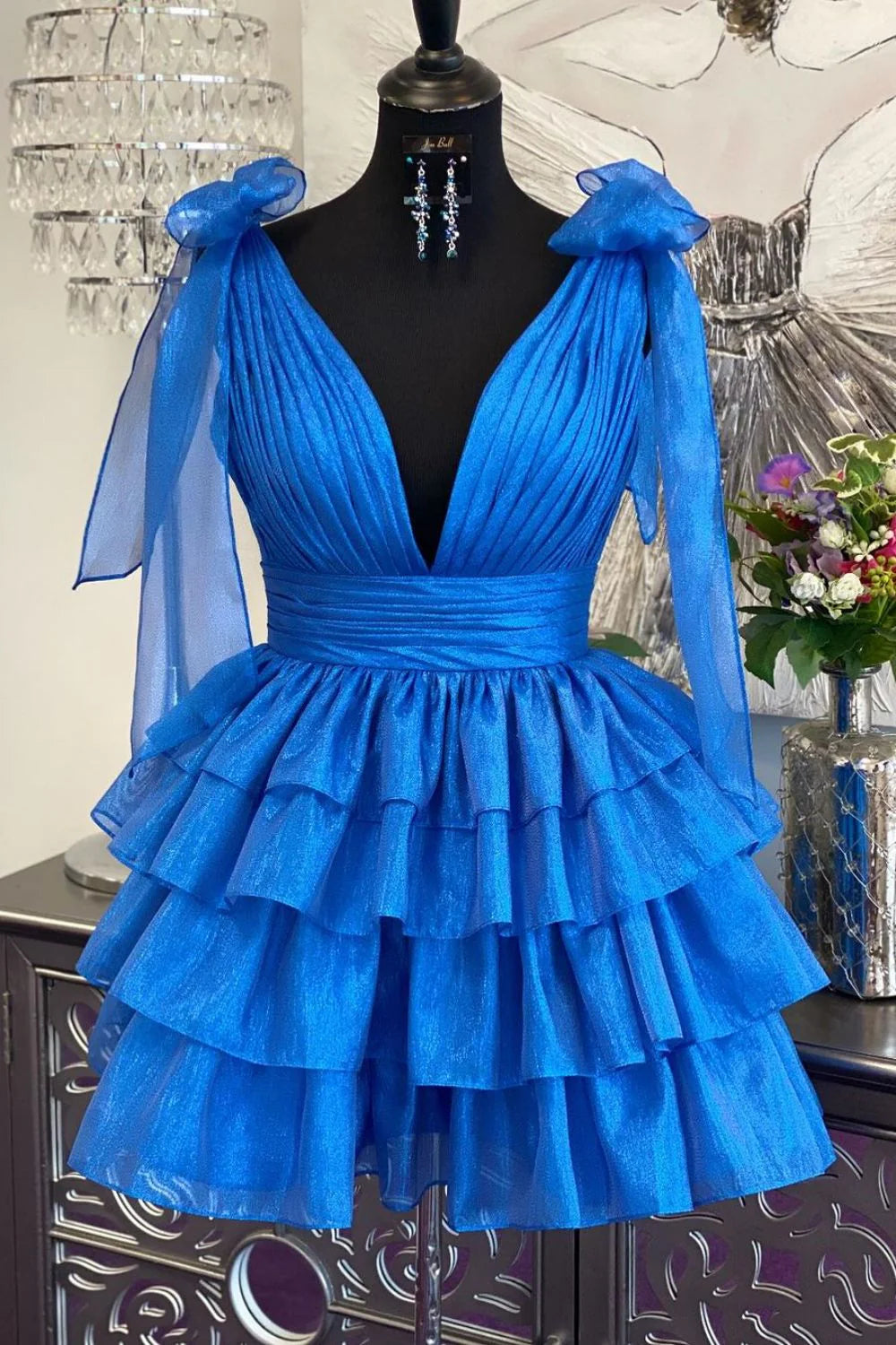 Model posing in the stylish tiered satin homecoming dress.