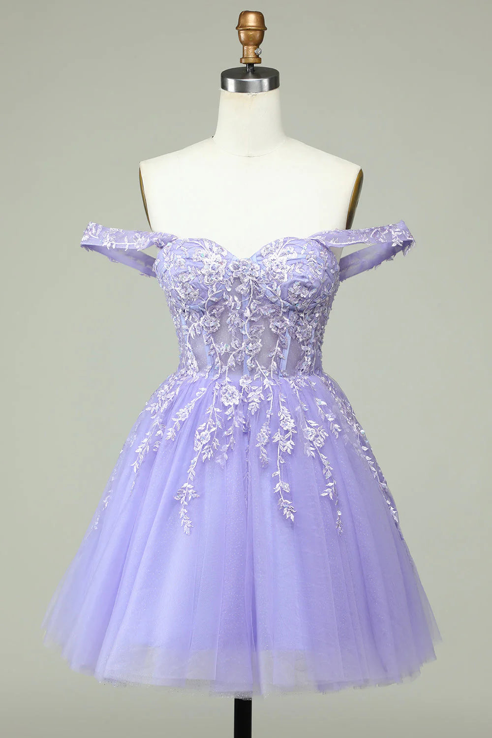 Model wearing a lilac A-line off-shoulder short homecoming dress with corset and appliques, front view.