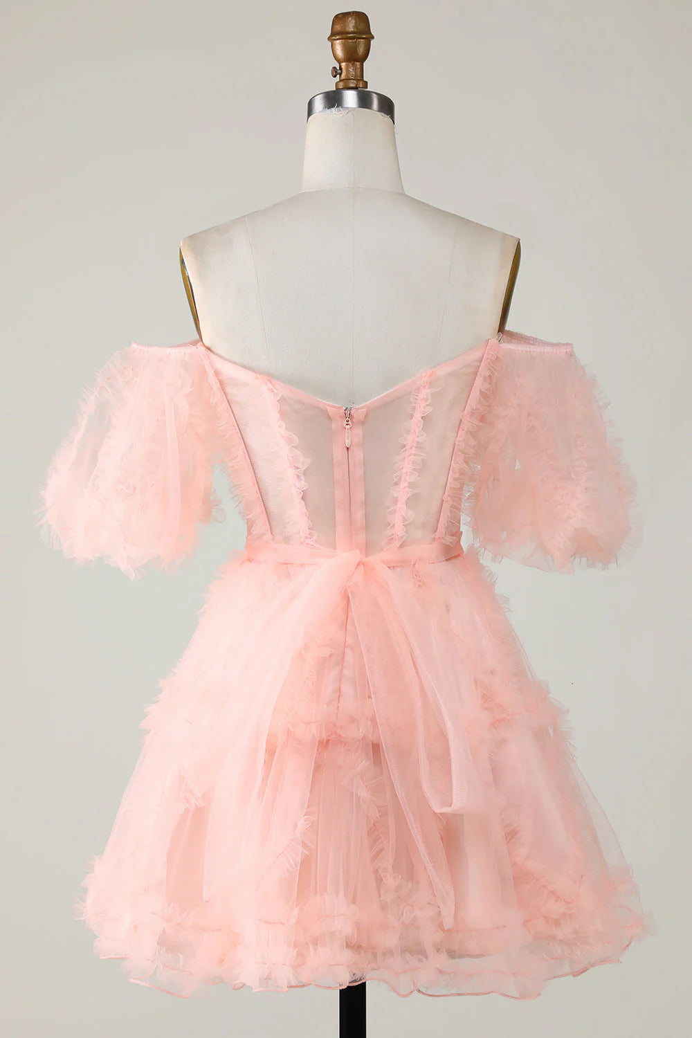 Side view of a model wearing a blush A-line off-shoulder short tulle homecoming dress.
