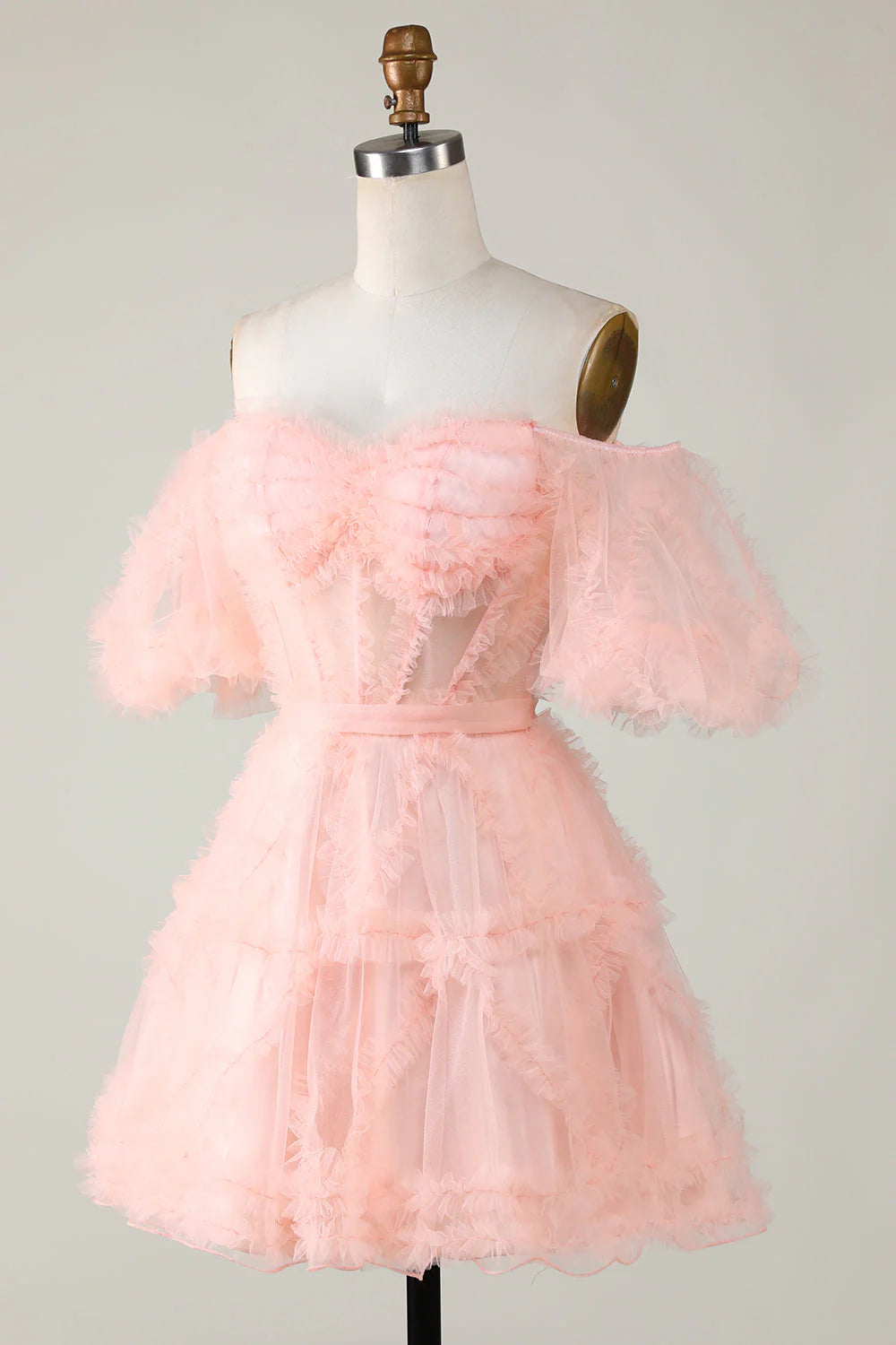 Back view of a model wearing a blush A-line off-shoulder short tulle homecoming dress.
