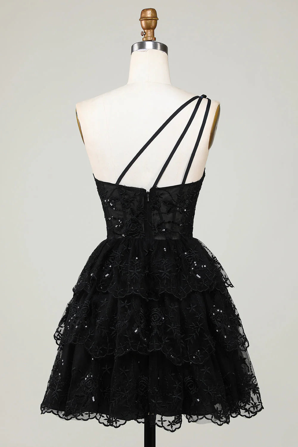 Side view of black one-shoulder tiered short homecoming dress.