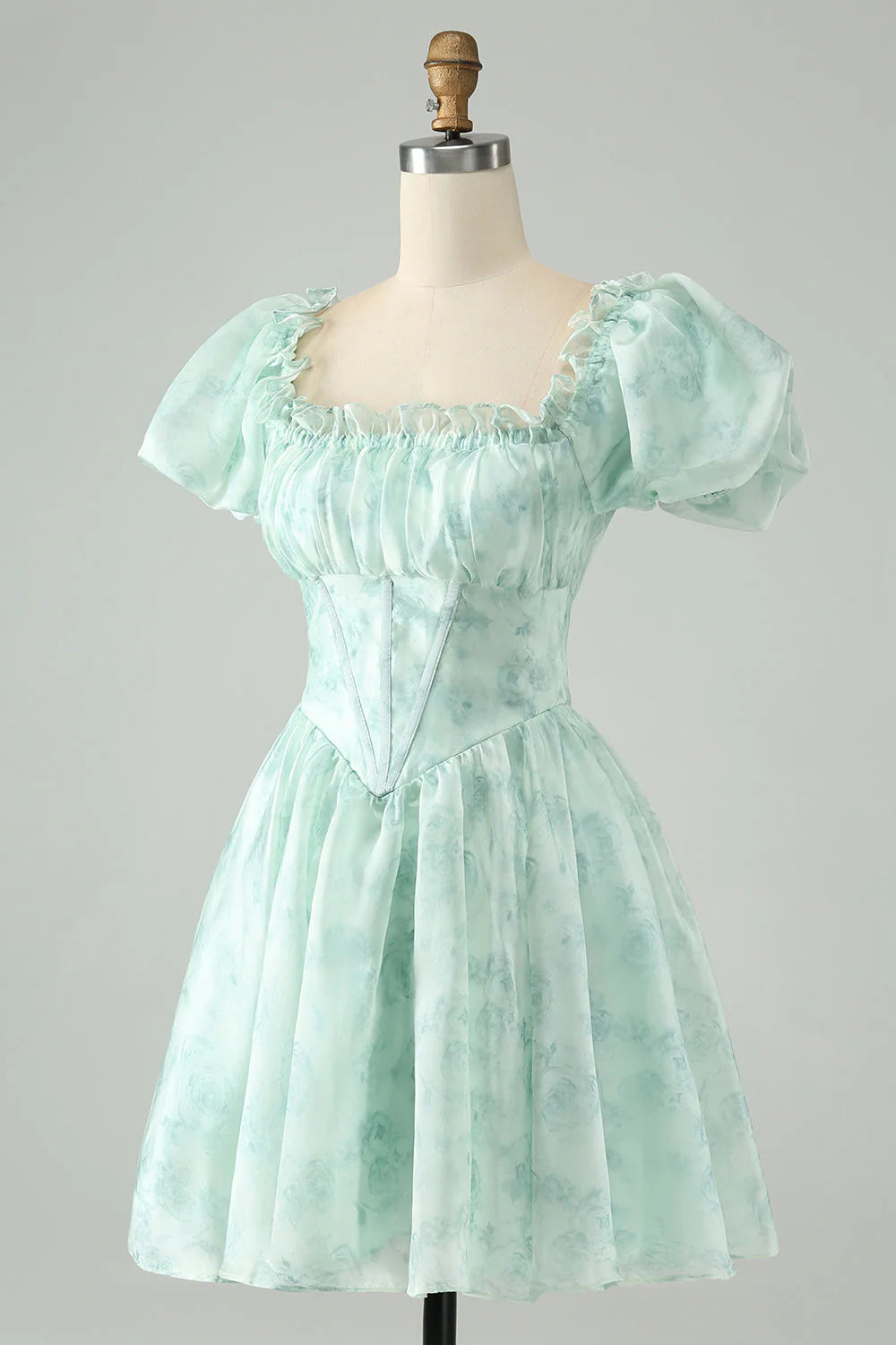 Close-up of the square neckline and floral details on a light green homecoming dress.