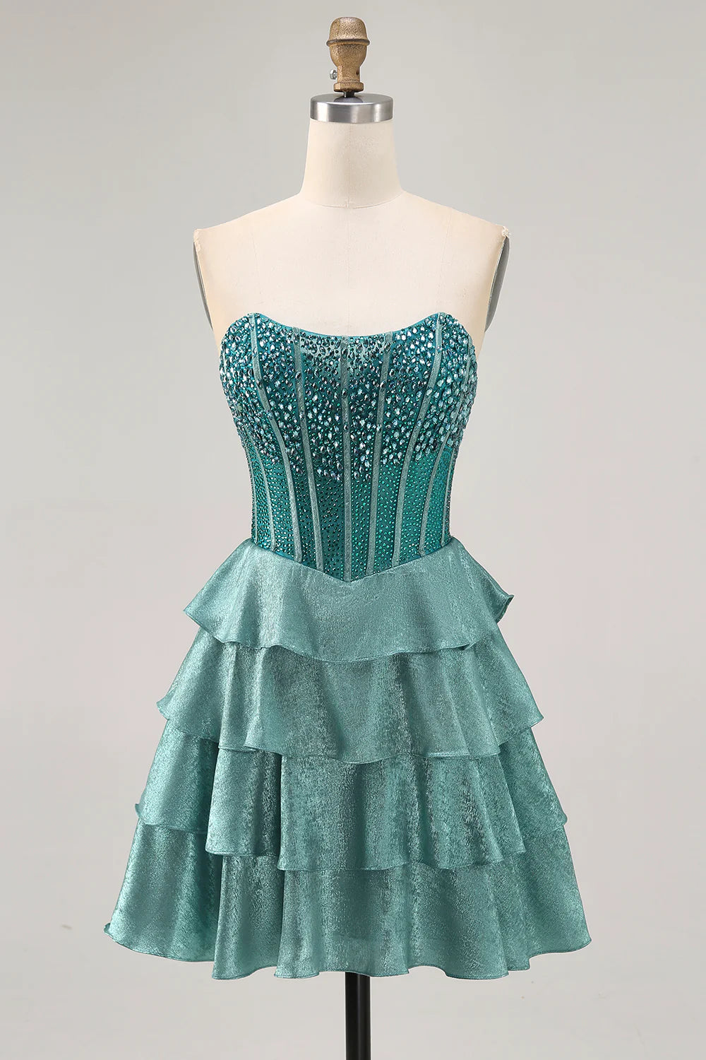 Peacock green A-line strapless dress with beading and tiers.