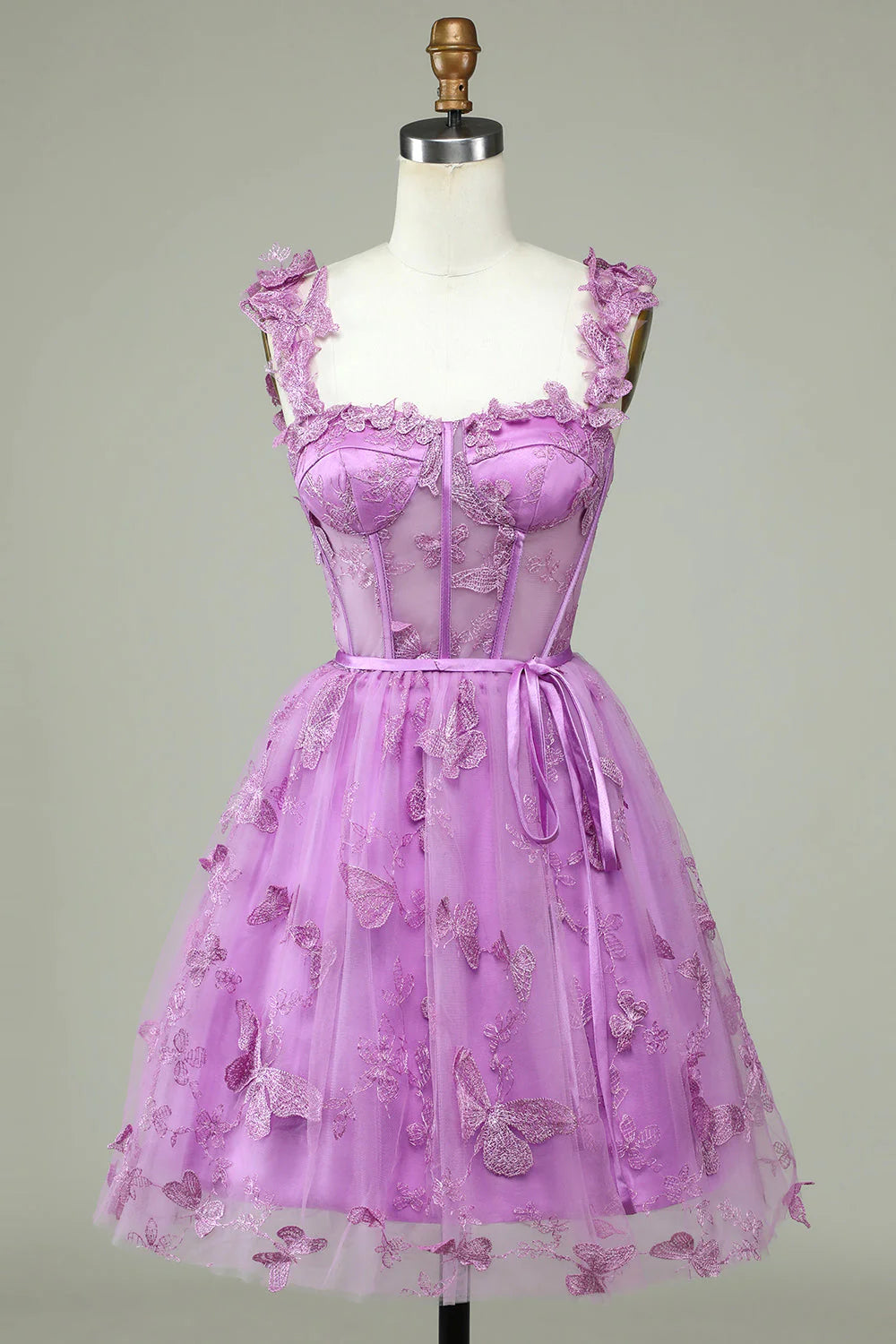 Model wearing a purple A-line short homecoming dress with a corset bodice and appliques.
