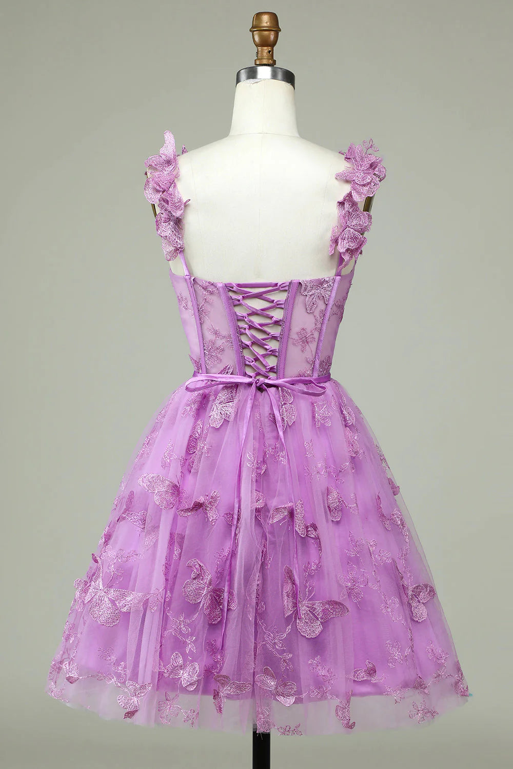 Side view of a model in a purple A-line short homecoming dress with appliques.