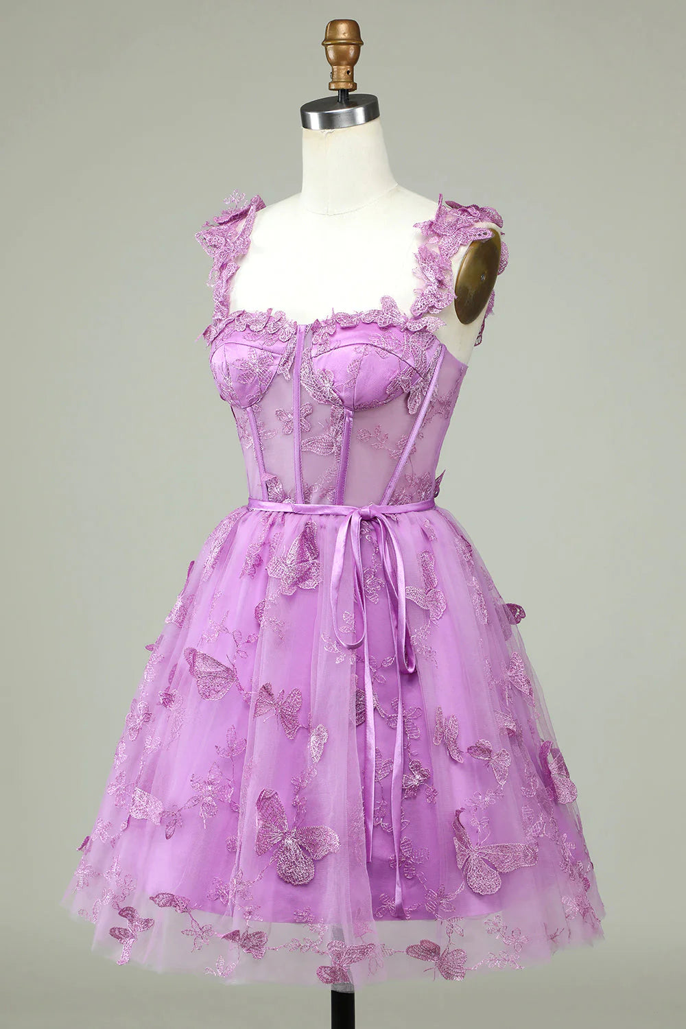 Back view of a purple A-line short homecoming dress showing corset lacing and appliques.
