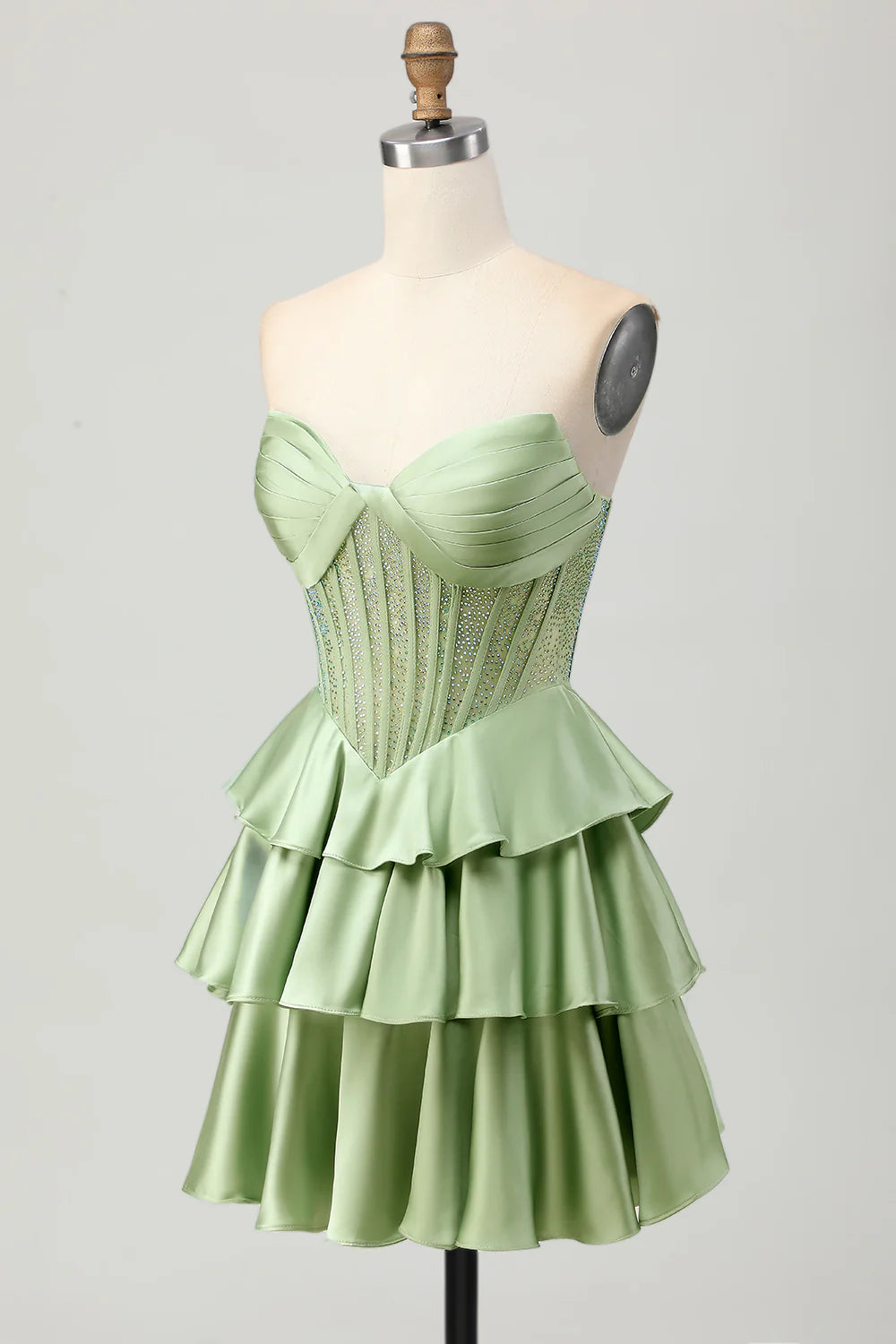 Detail of the tiered skirt and satin fabric of the dark green dress.