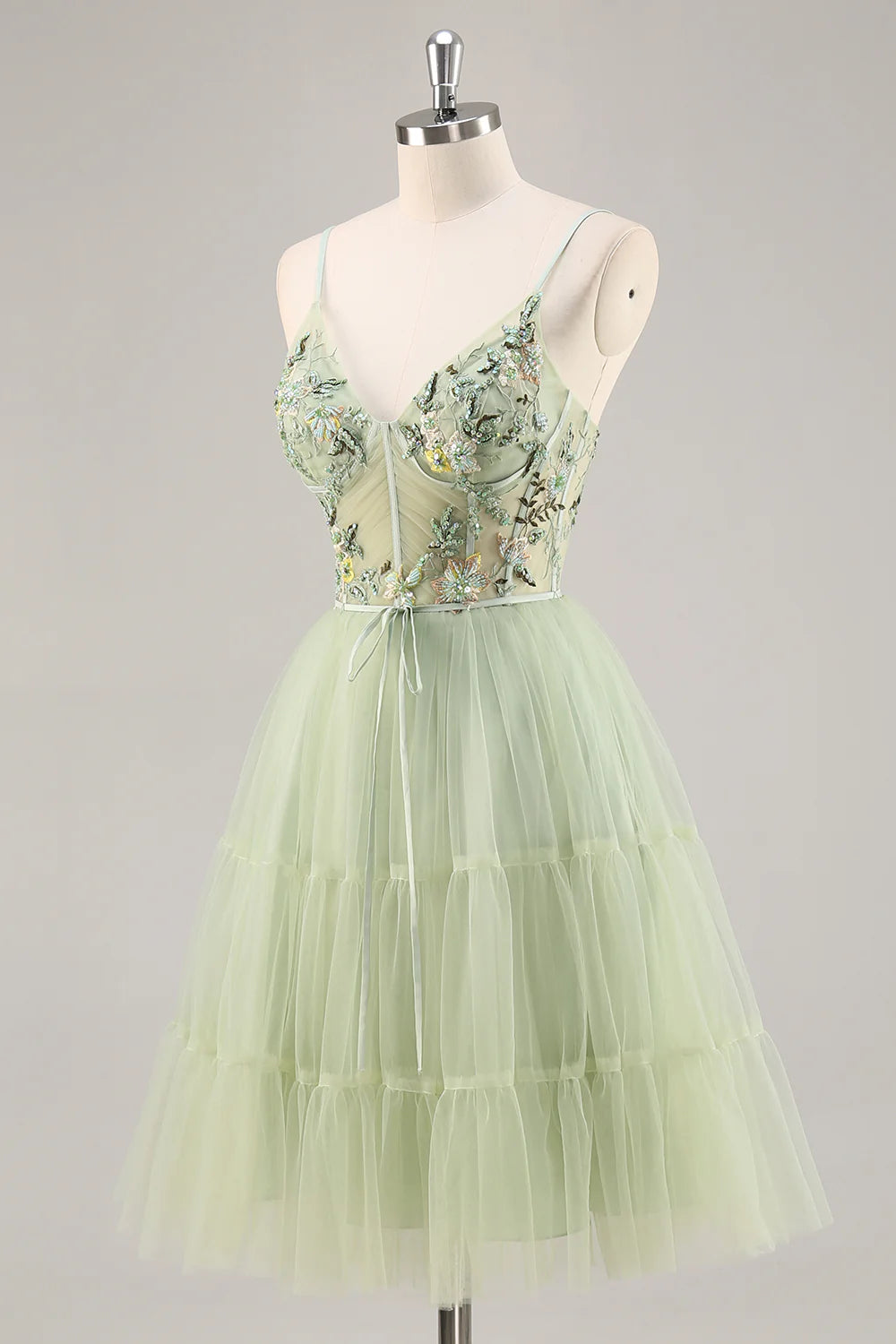 Back view of a green A-line homecoming dress with intricate floral details.