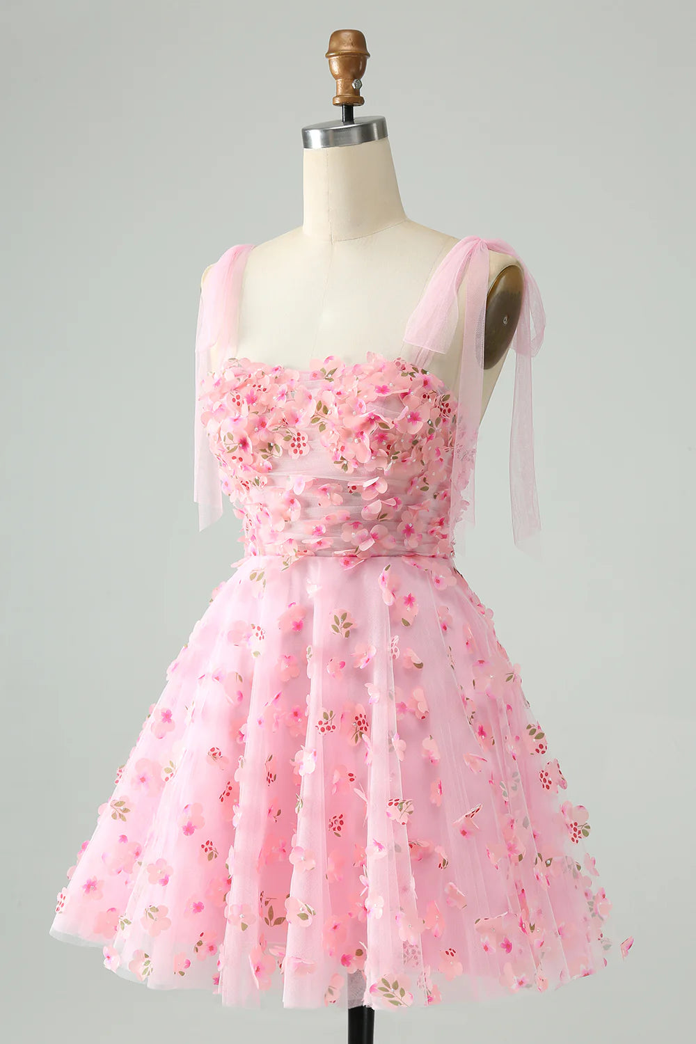 Side view of a pink A-line short homecoming dress with pearl and applique embellishments.