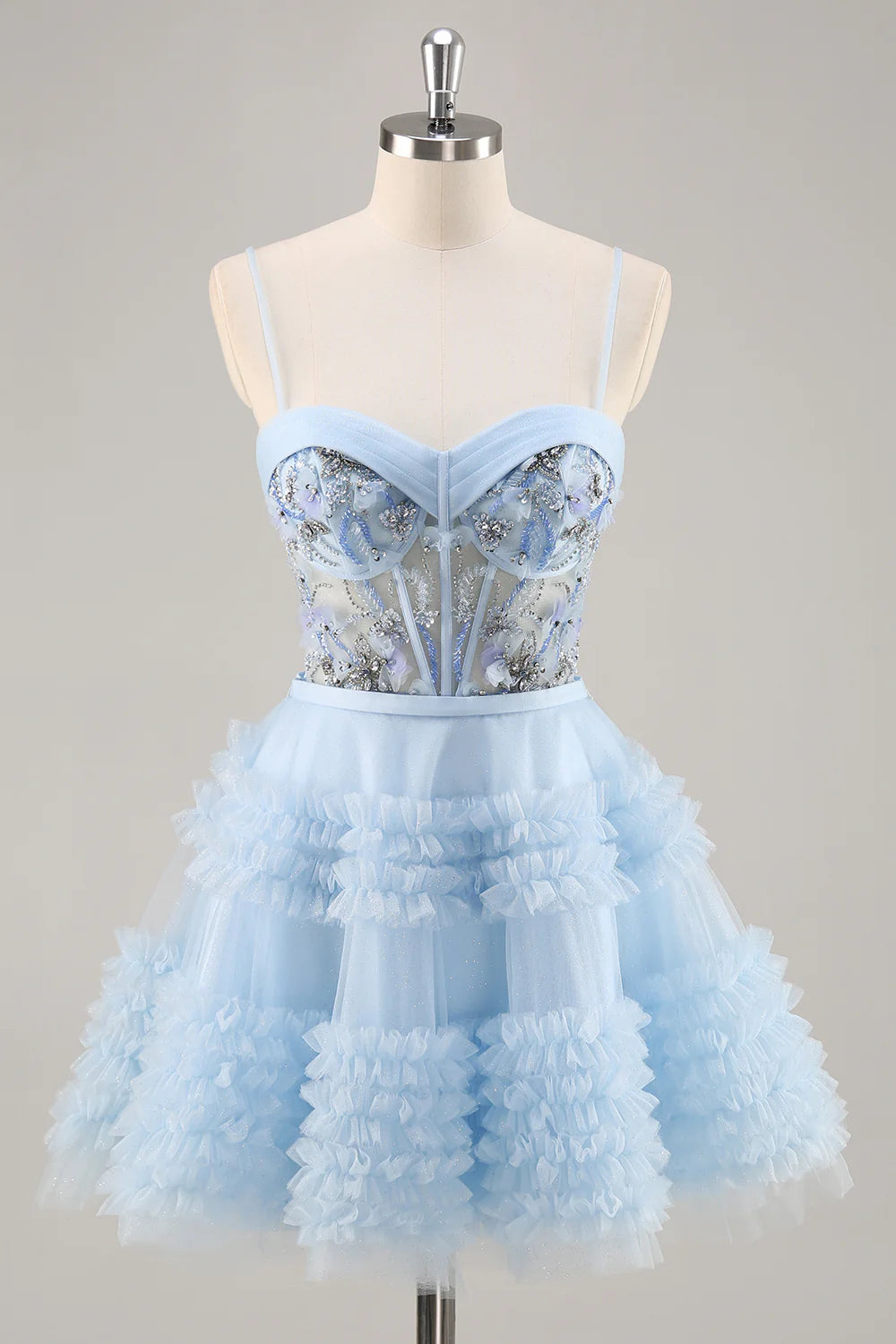 Model wearing a blue A-line short homecoming dress with sequins, tulle, and ruffles.