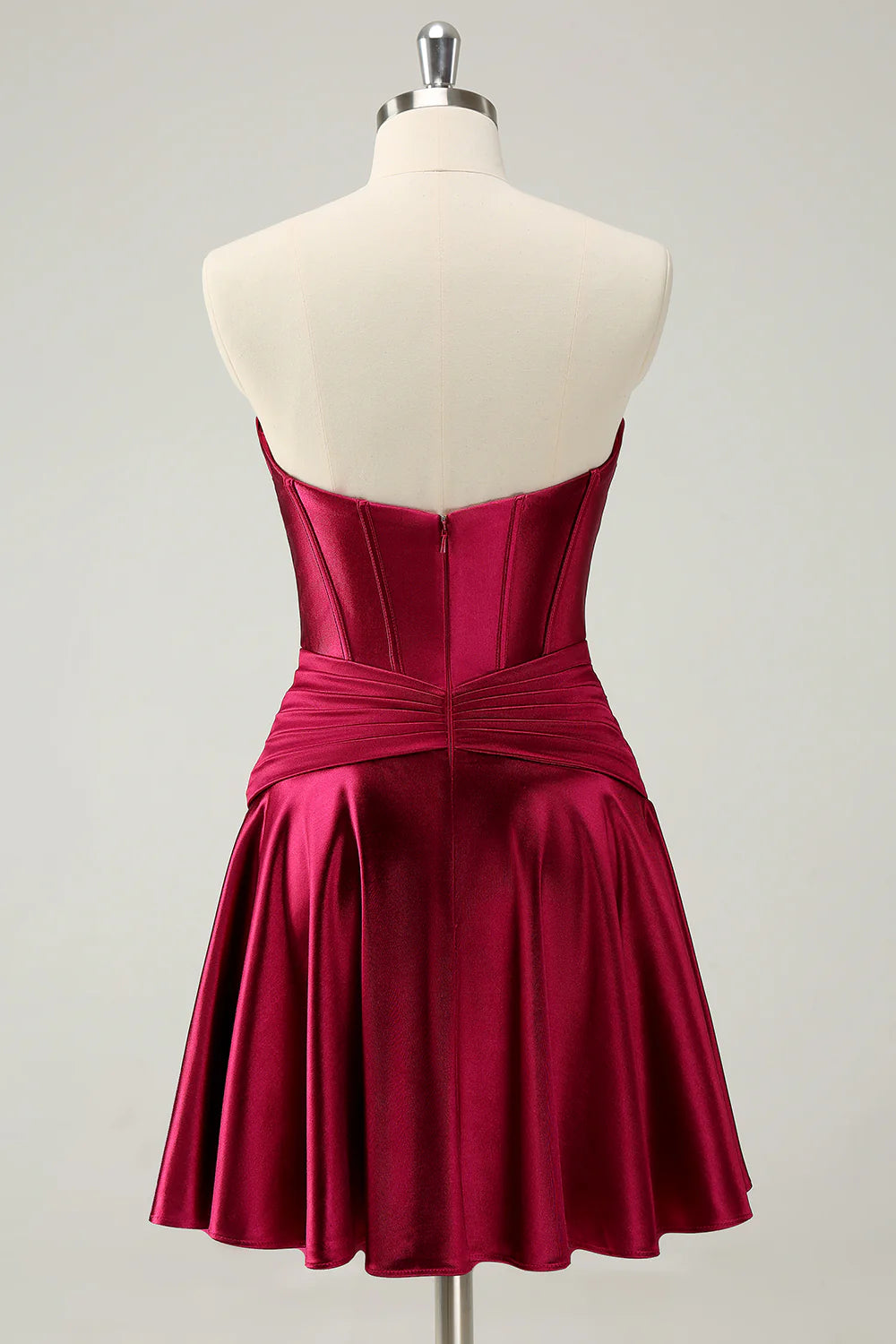 Back view of a burgundy A-line homecoming dress showing criss-cross corset and ruffled skirt.