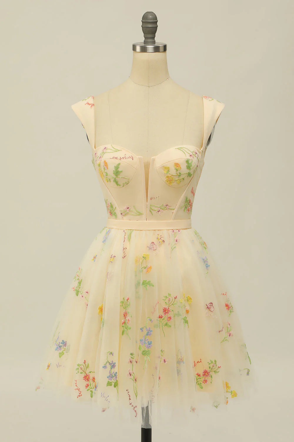 Model wearing a sophisticated champagne A-line short homecoming dress with sweetheart neckline.