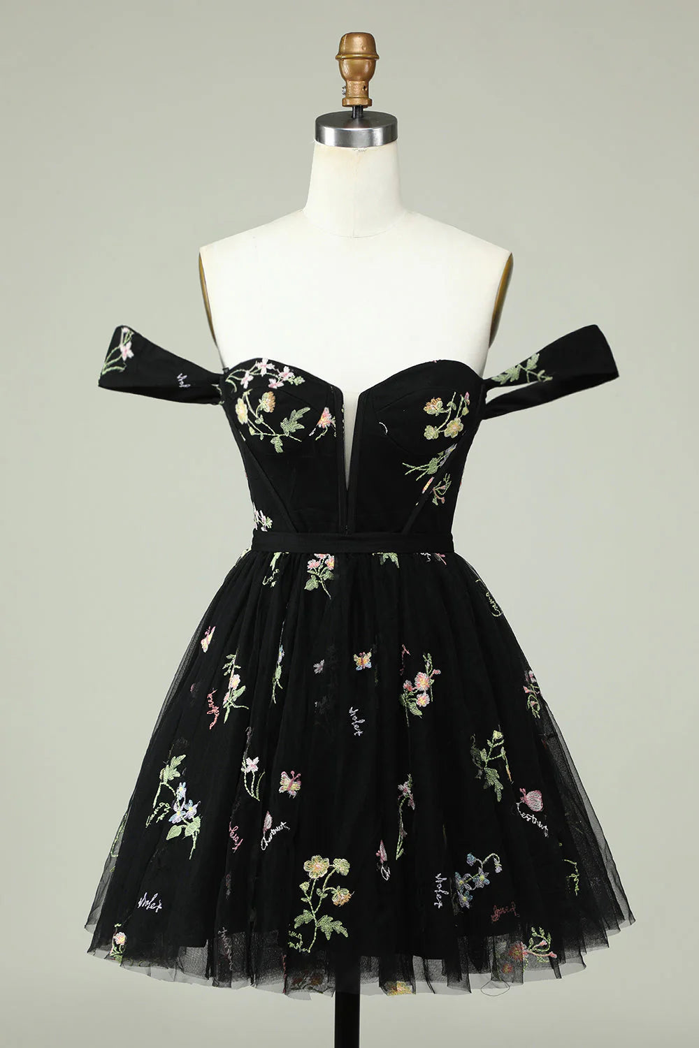 Model wearing a classic black A-line short homecoming dress, suitable for formal occasions.