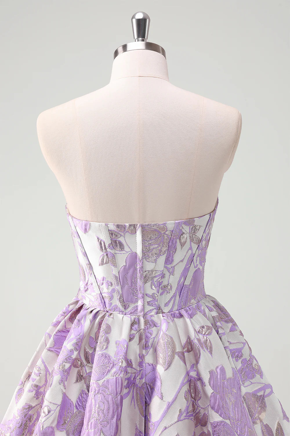 Close-up of the ruffled skirt detail on a lilac satin ball gown.