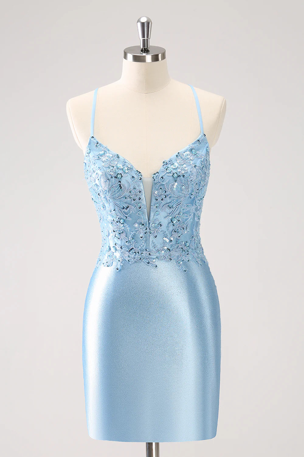 Model wearing a blue bodycon sequin short homecoming dress with a lace-up back.