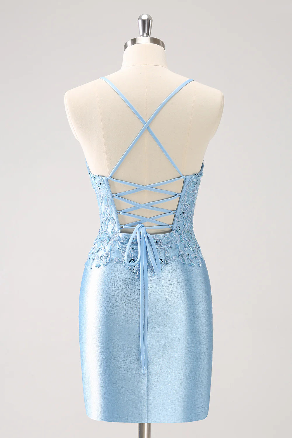 Side view of a blue sequin short dress with appliques and a flattering silhouette.