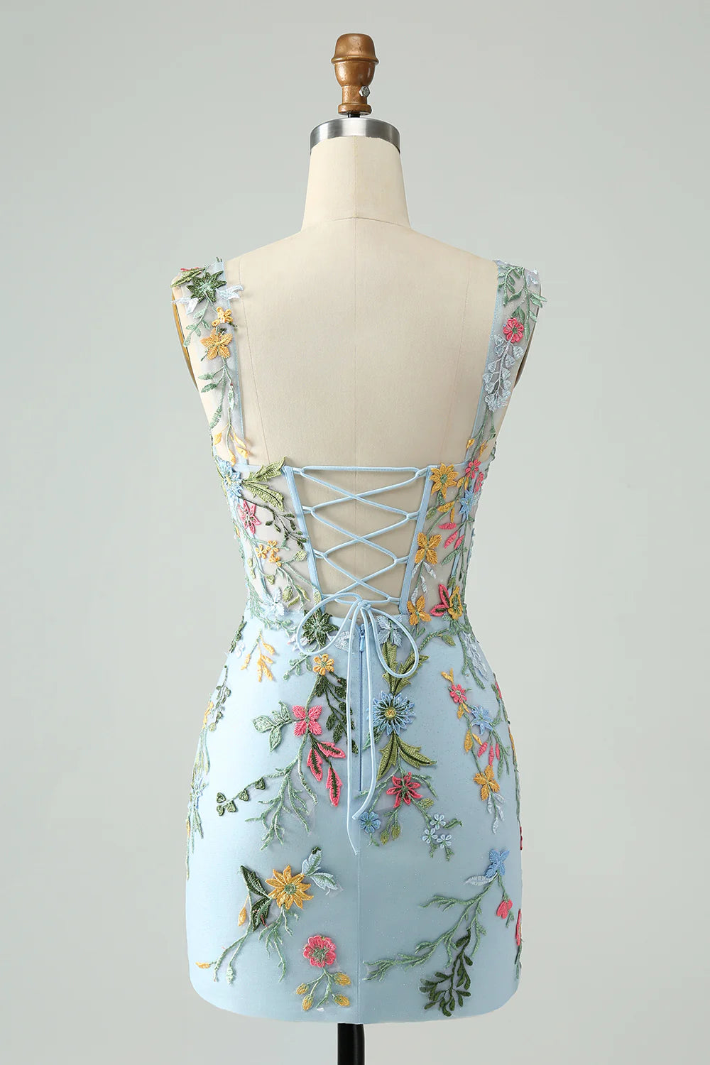 Model posing in a blue floral off-shoulder short homecoming dress.