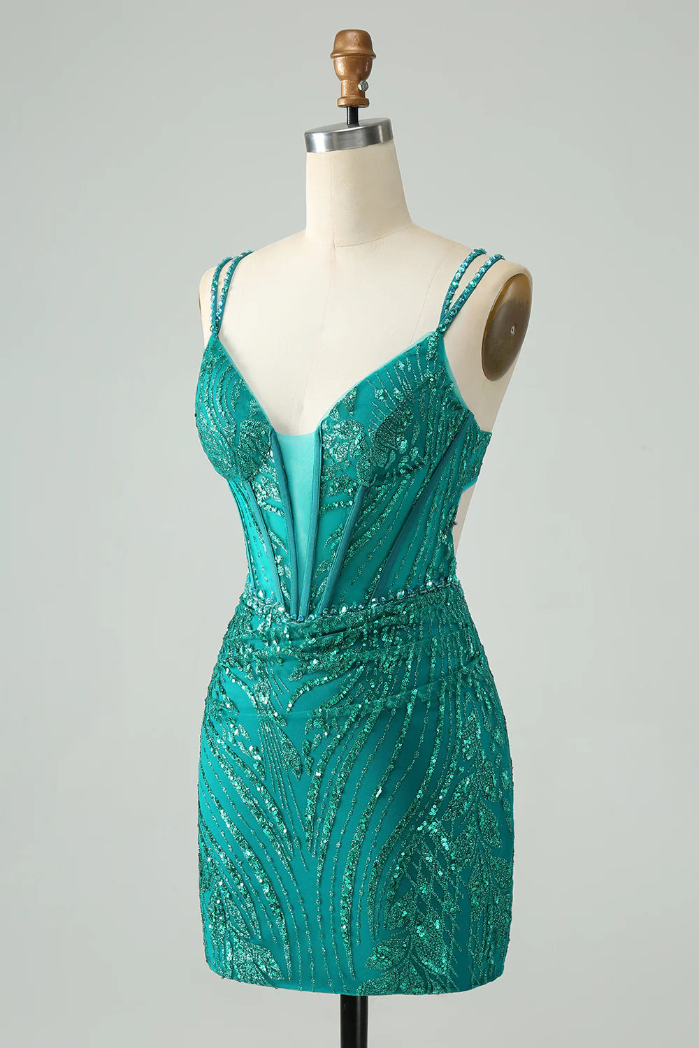 Back view of a dark green sequin short homecoming dress with spaghetti straps.