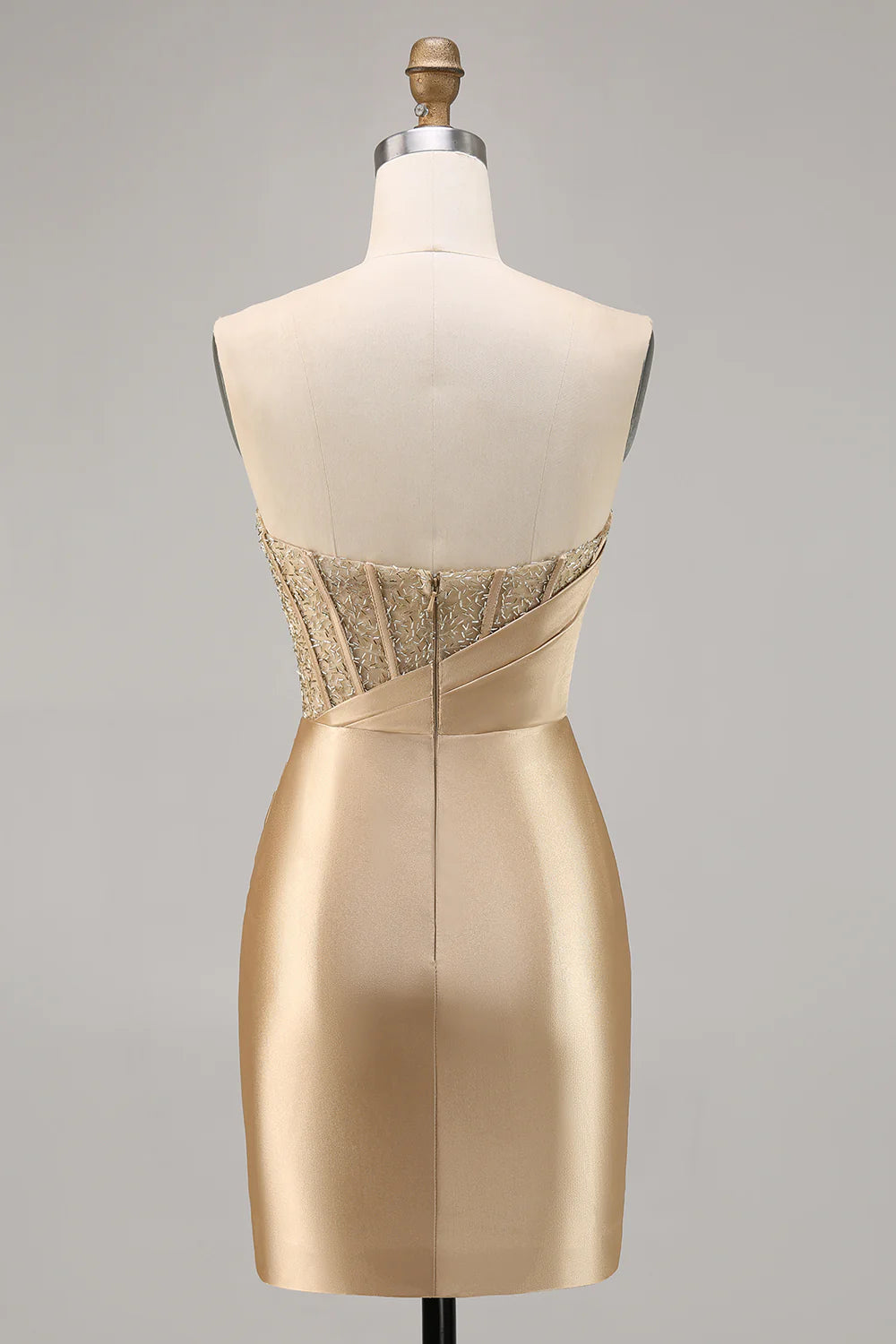 Back view of a model in a golden strapless satin bodycon dress.