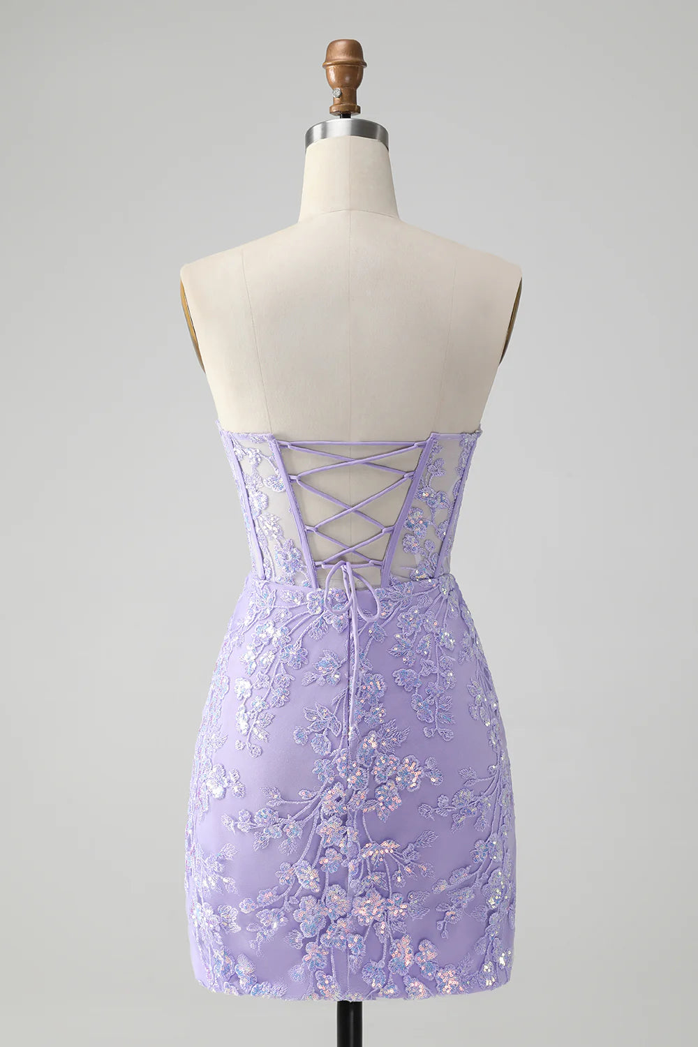 Back view of a model in a lilac sequin bodycon homecoming dress, showing corset detail.