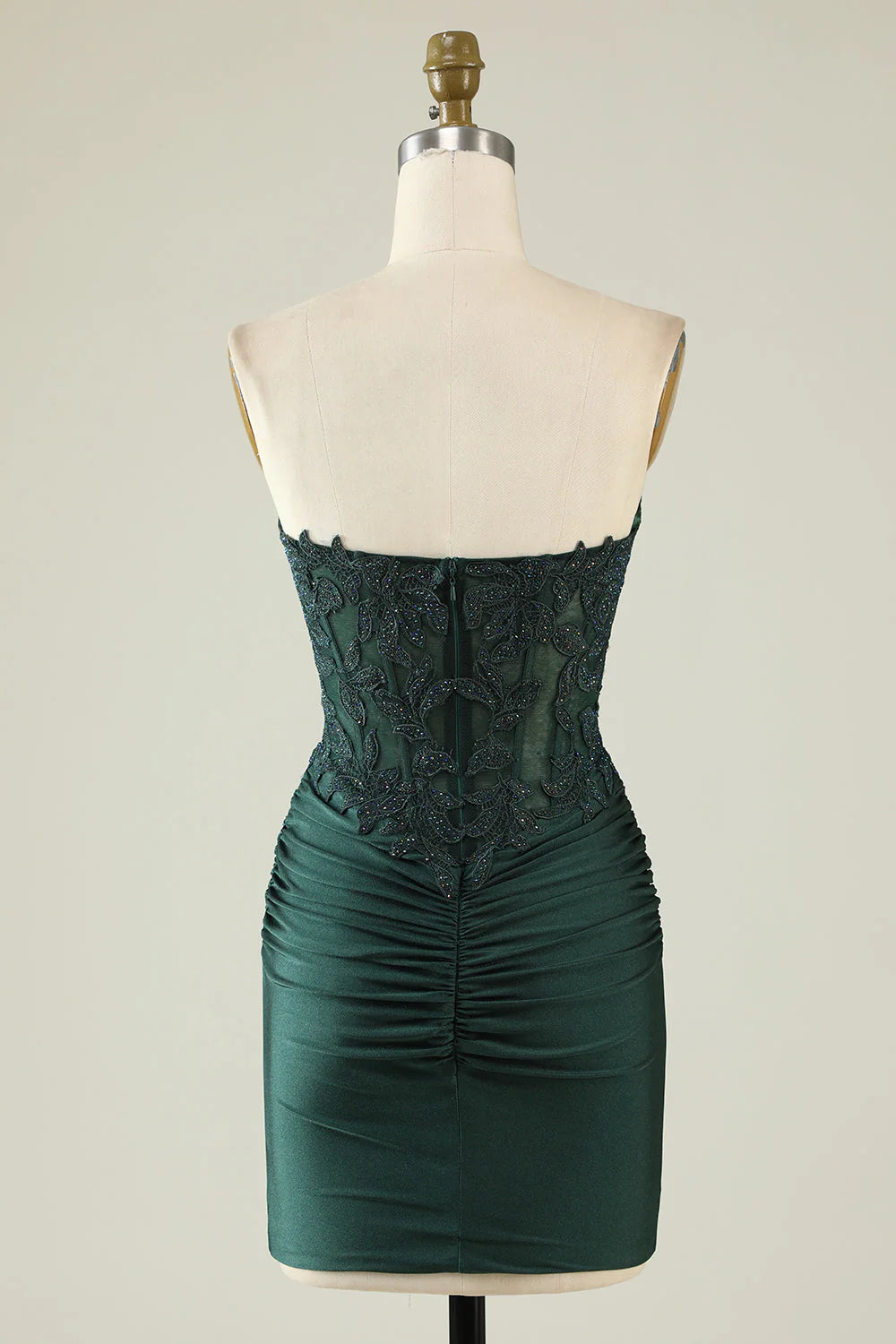 Back view of dark green bodycon strapless dress showing intricate beading.