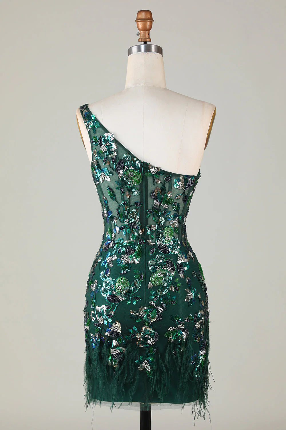 Side view of a dark green sequin dress, showcasing the one-shoulder design and feather details.