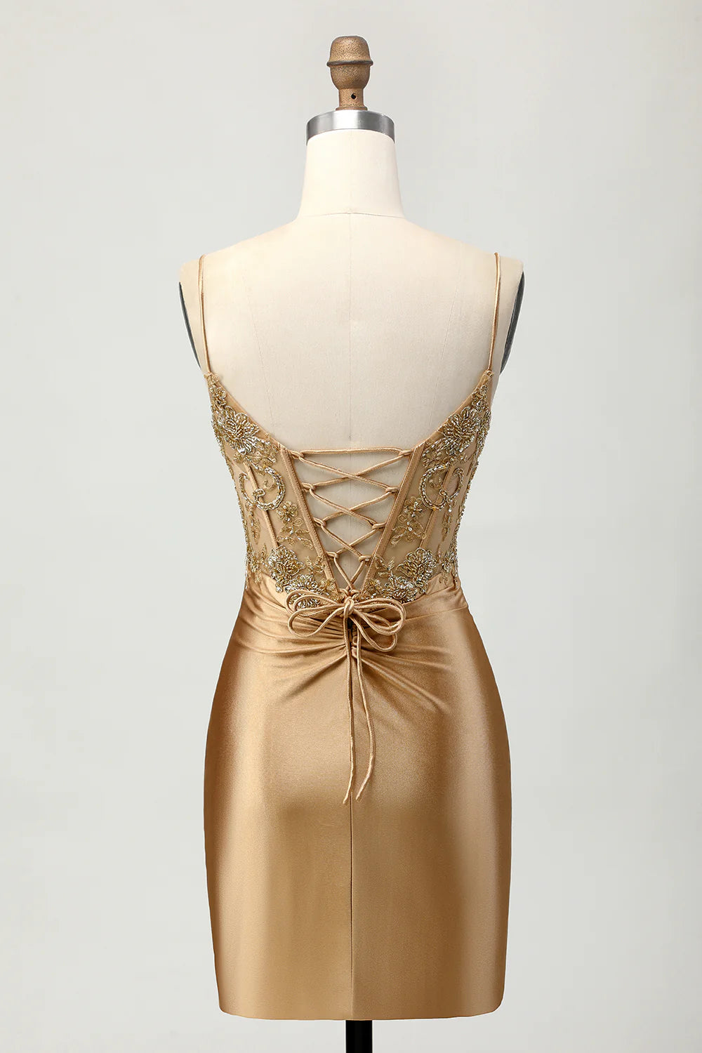 Back view of golden satin short homecoming dress showing lace-up detail.