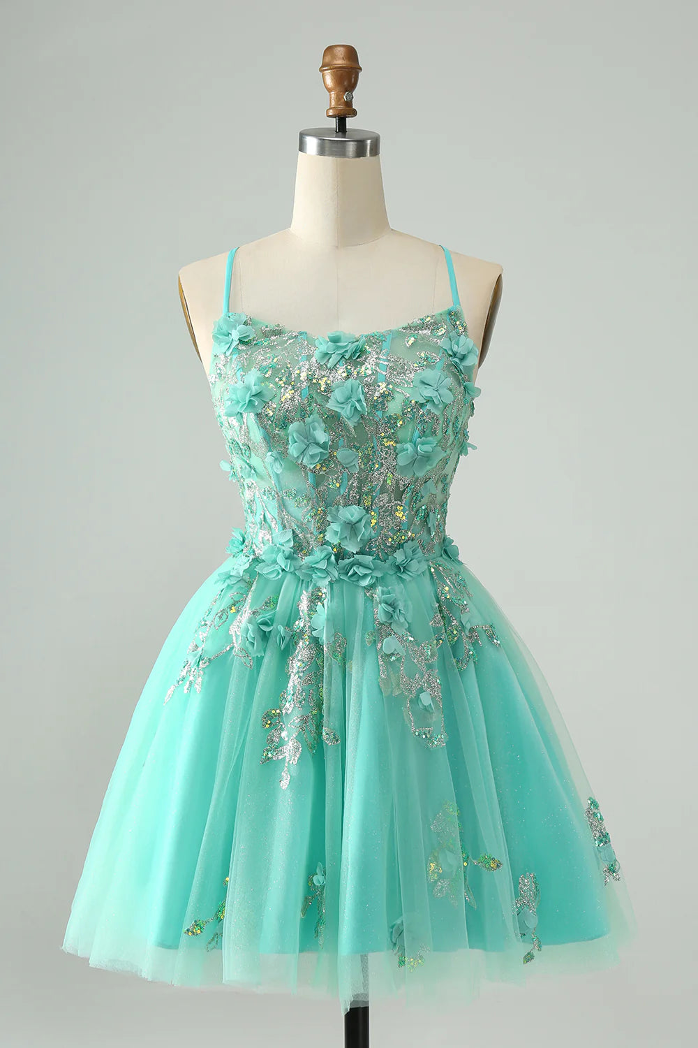 Full view of an elegant green A-line short homecoming dress with spaghetti straps, corset, and appliques.