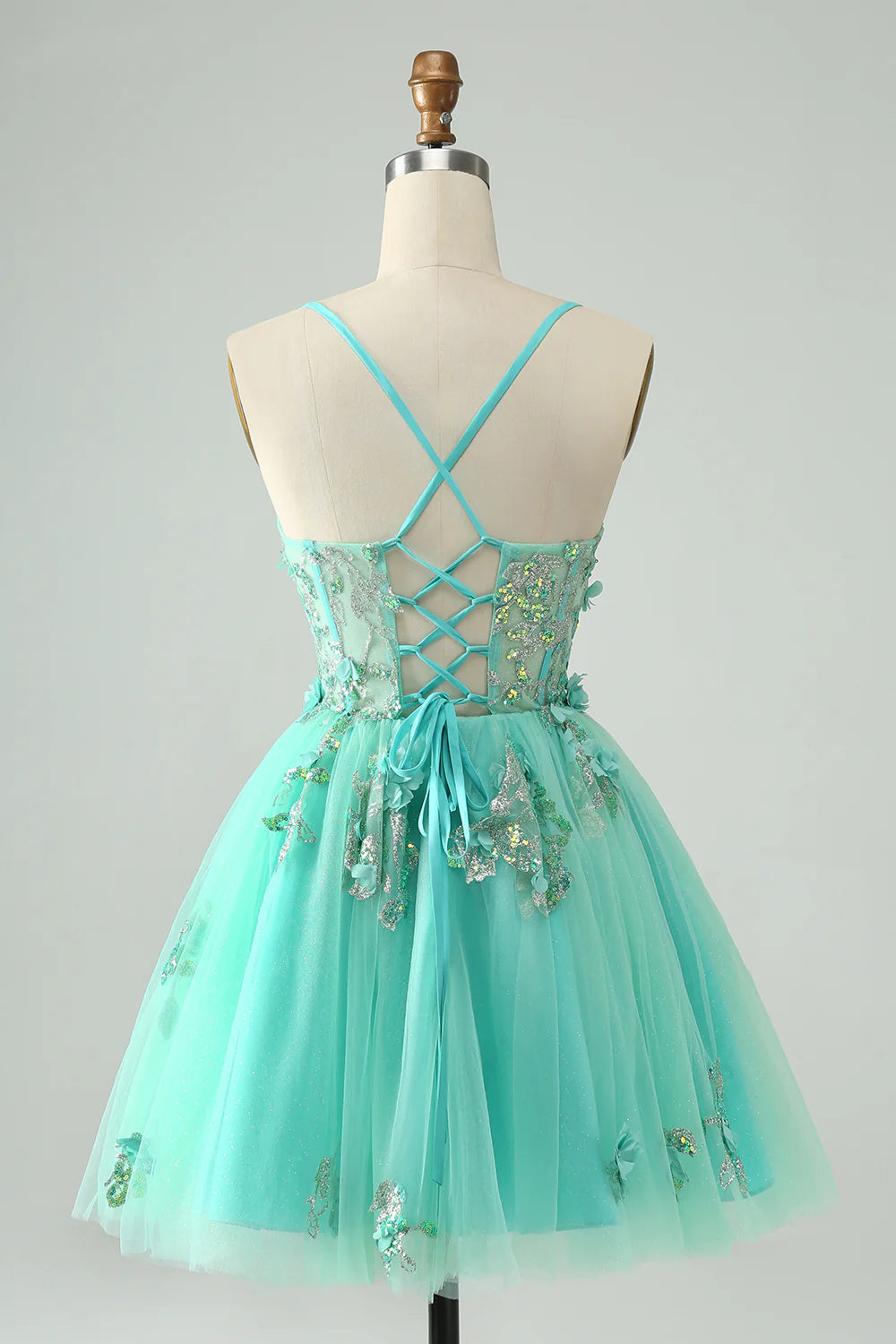 Side view of the green A-line short homecoming dress, showcasing the delicate appliques.