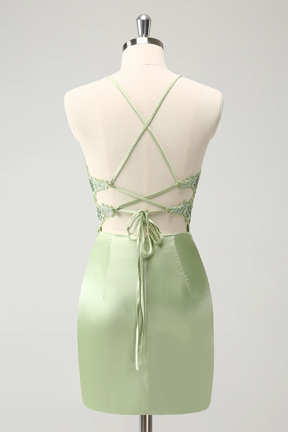Back view of green sheath dress showing criss-cross detail and corset.