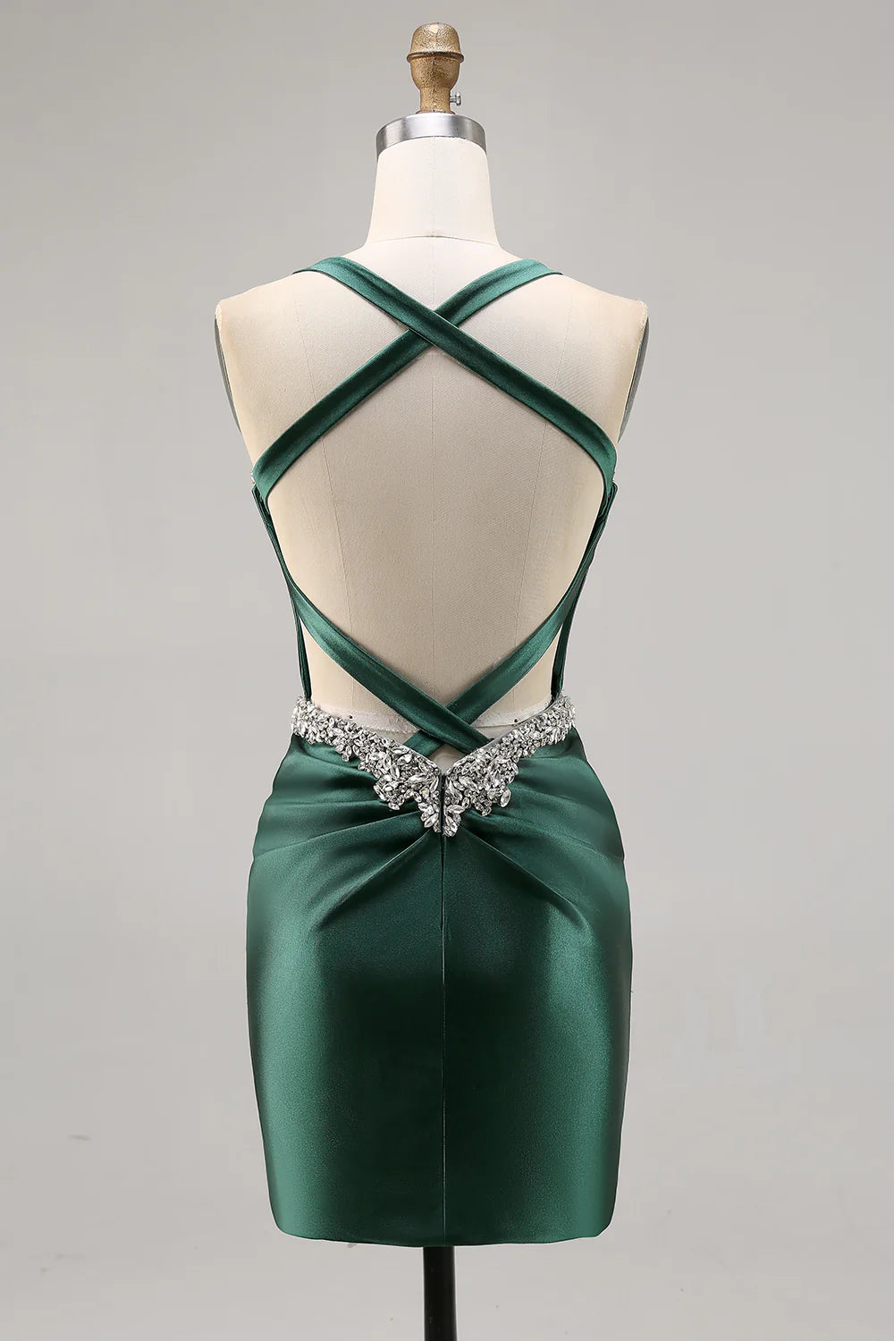 Side view of a model in a dark green halter bodycon satin dress.