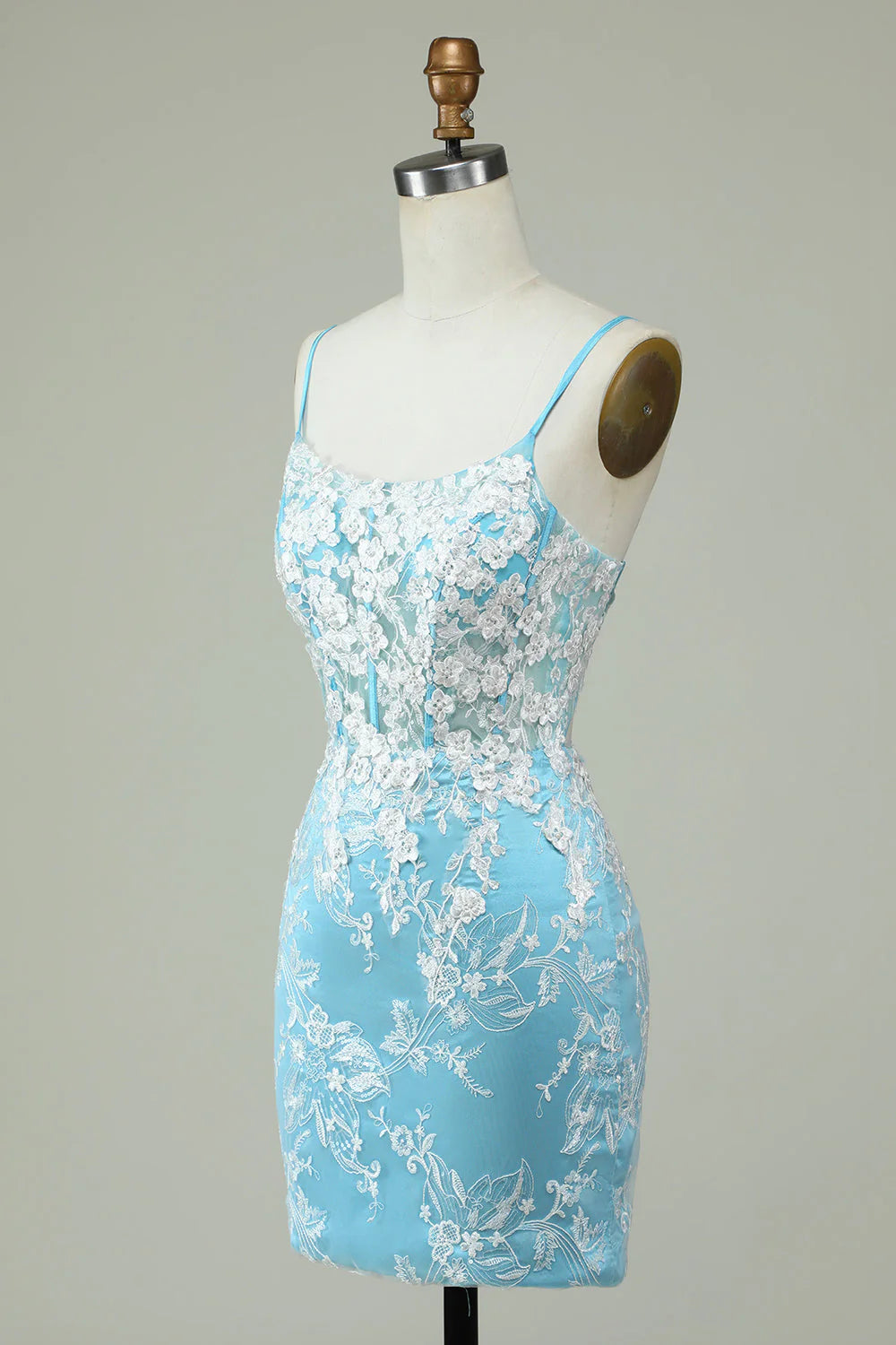 Close-up of delicate appliques on the light blue satin fabric of the short homecoming dress.